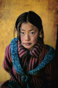 Girl in New Coat (Fille dans un manteau neuf), Xigaze, Tibet, 2001 - Steve McCurry (portrait couleur)