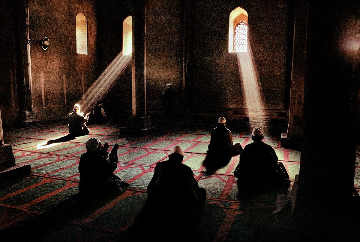 Steve McCurry Color Photograph - Men praying in a mosque, Srinagar, Kashmir