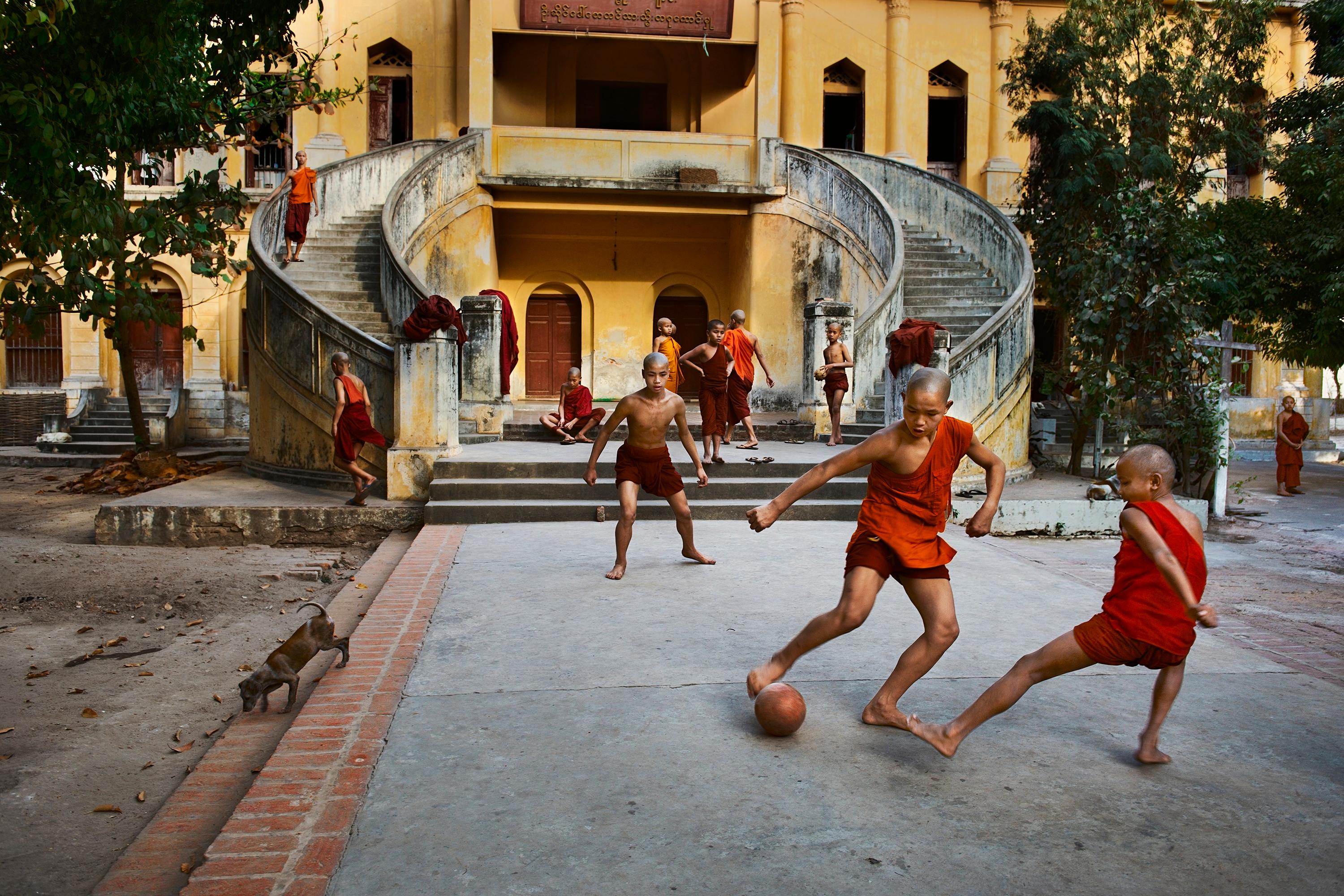 Monks Play Football, Burma - Photograph by Steve McCurry