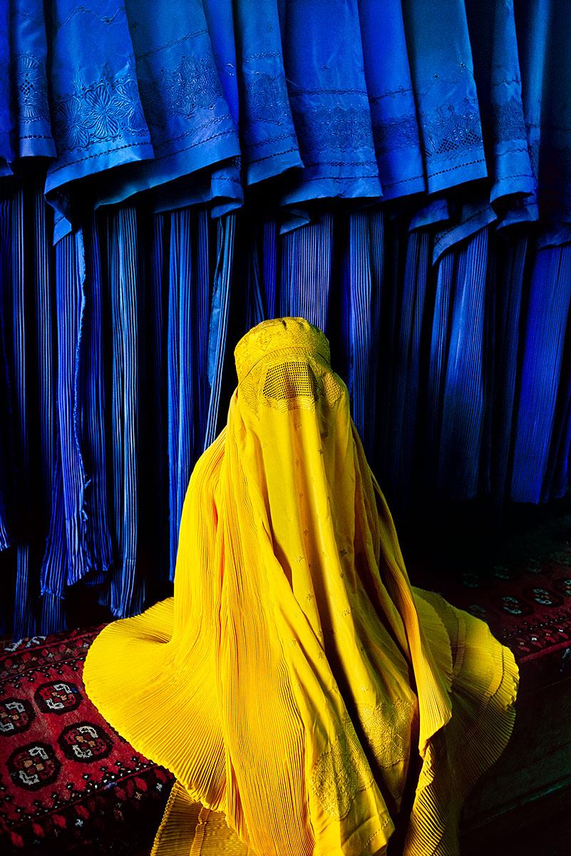 Woman in Canary Burqa by Steve McCurry is a 24 x 20 inch digital c-print on FujiFlex Crystal Archive Supergloss paper, available in an edition of 30. This photograph features a portrait of a woman in a bright yellow burqa, sitting in front of a