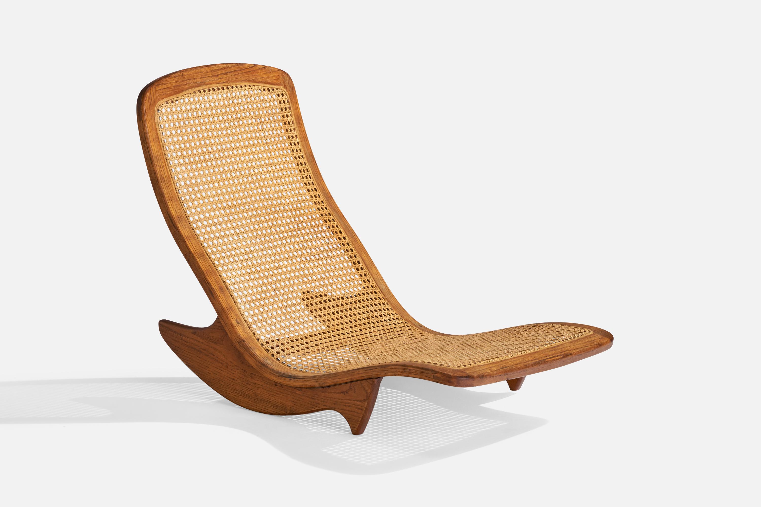 A teak and rattan rocking low chair or chaise longue designed and produced by Steve Rieman, USA, c. 1976

Seat height 5”.