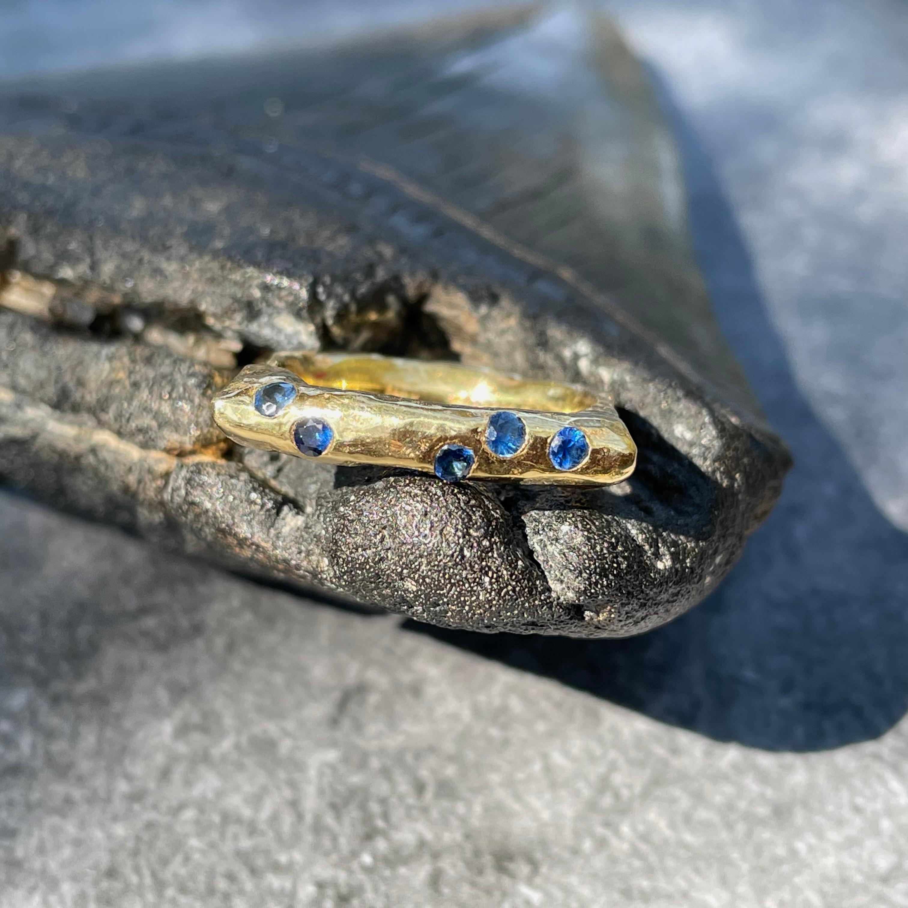 A Steven Battelle designed multi-stone ring set with five 1.8 to 2 mm blue sapphires in a unique organic heavy sculpted shank currently sized 7.  We call this a 