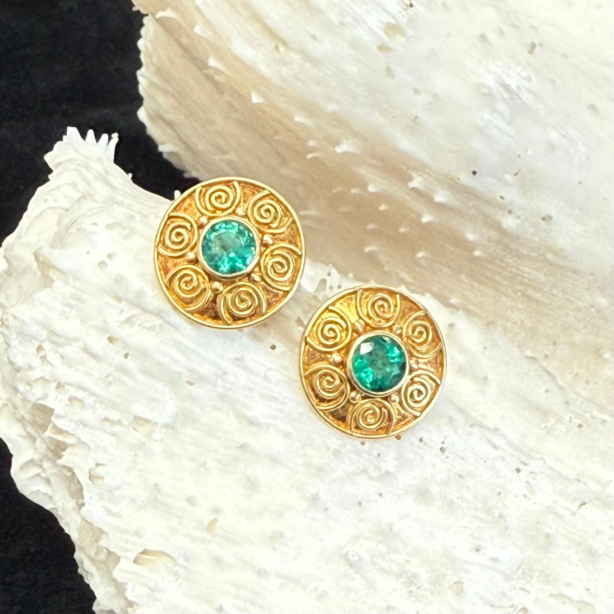 Two brilliant 4mm round faceted emeralds are surrounded by multiple hand applied spirals in this ancient-inspired handmade design. Overall diameter is 11mm.  A nice matte-finish completes this classic design. Simply beautiful!