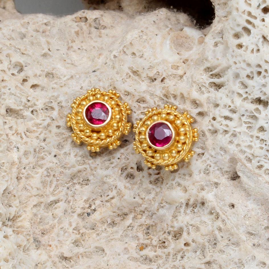 Two 3mm round faceted rubies are surrounded by meticulously placed high-karat gold 