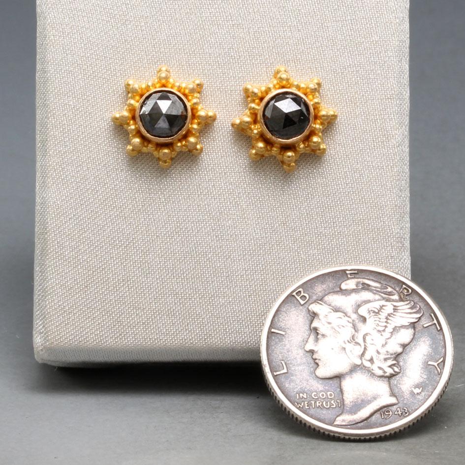Two lustrous 5mm rose faceted black diamonds are surrounded by stacked starburst pattern 