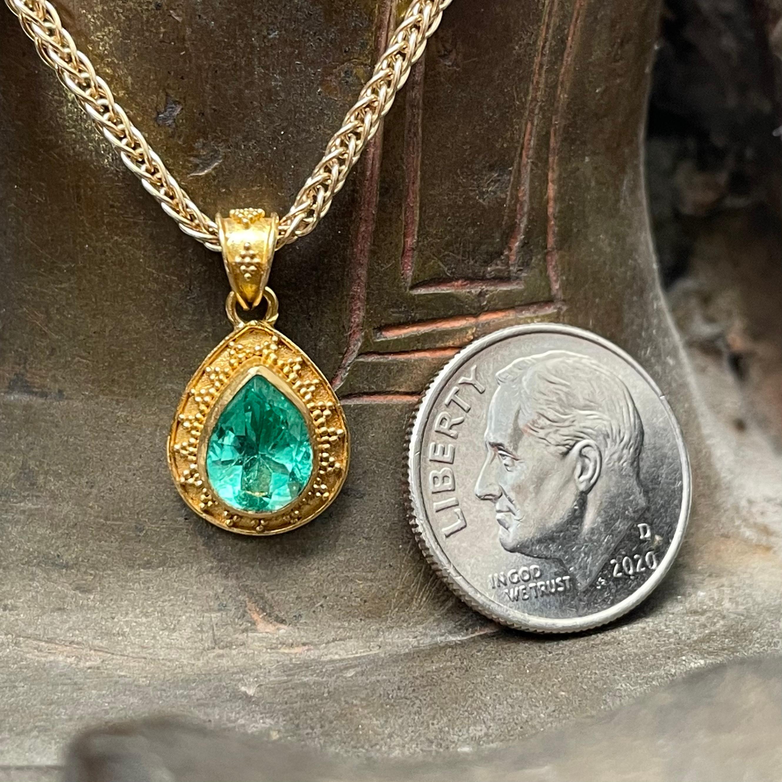 Une émeraude de Colombie vert clair de 6 x 8 mm en forme de poire facettée est mise en valeur dans ce design en or à haute teneur en carats fait à la main avec une granulation géométrique 