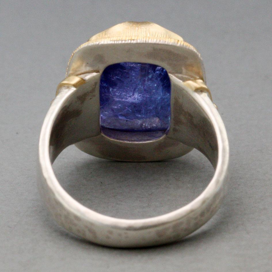 Une tanzanite coussin de 10 x 16 mm, d'un bleu pourpre profond et taillée en rose, est maintenue dans un chaton en or 18 carats d'inspiration médiévale 
