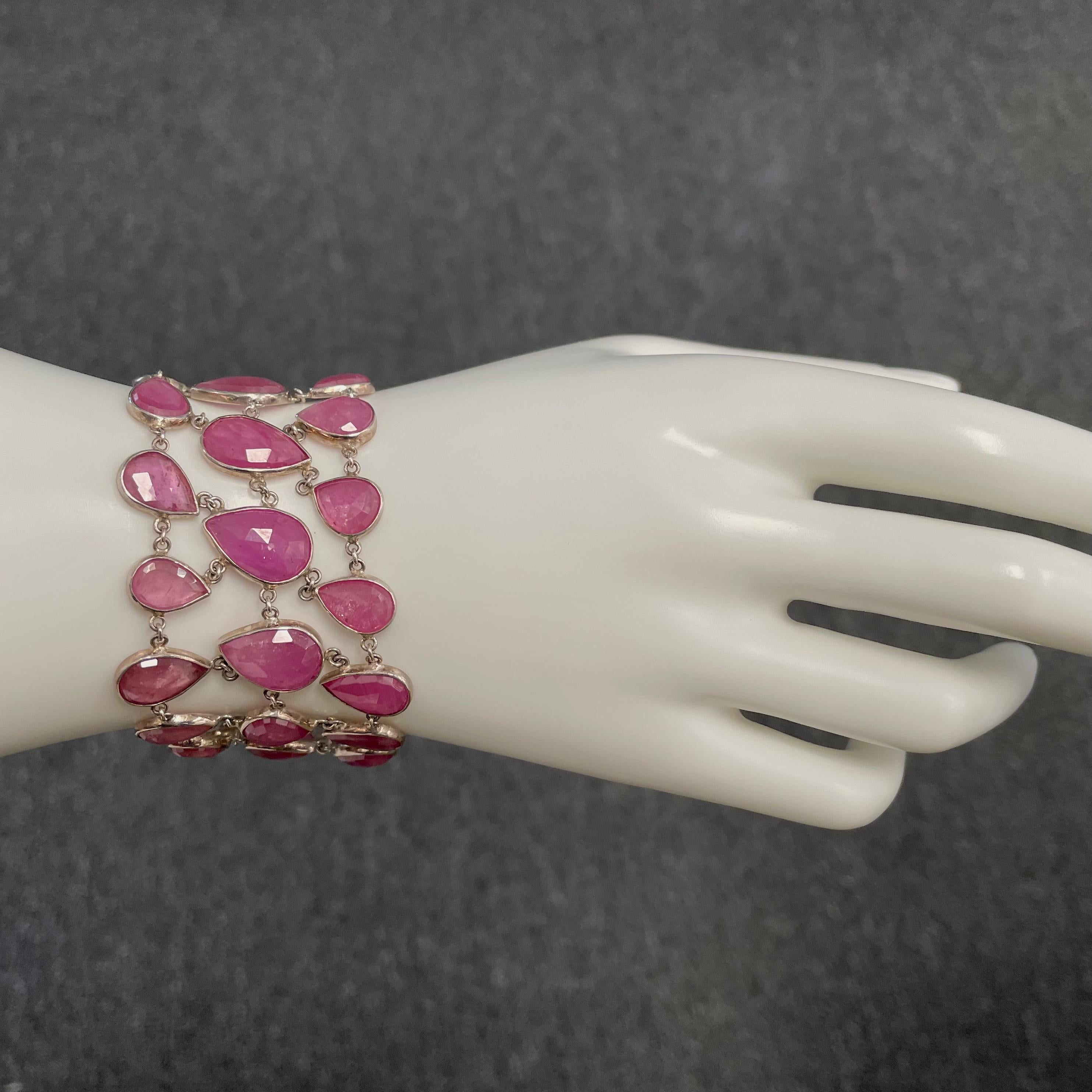 33 individual faceted pear shaped pink ruby stones from 6 x 9 mm to 9 x 15 mm are interlinked to form this beautiful and comfortable bracelet set in silver.  Current 7.5 inch length fits medium to larger wrists.  Fastens with a toggle clasp. It