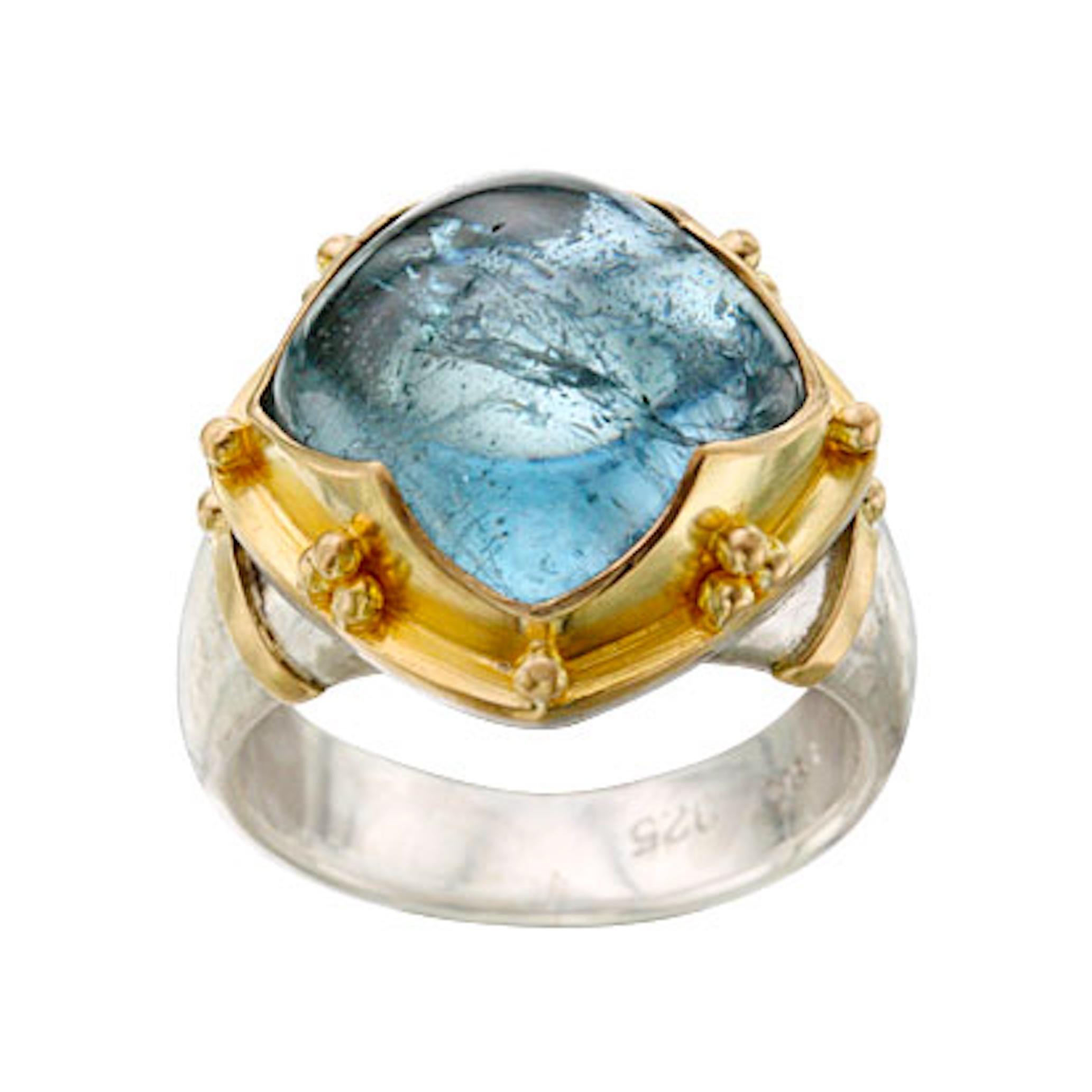 Un cabochon coussin bombé de 12 mm de hauteur en aigue-marine brésilienne est maintenu dans une signature 