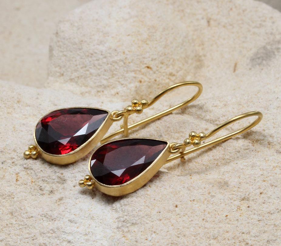 Two large 10 x 14 mm pear shaped faceted Mozambique garnets hang below quadruple 