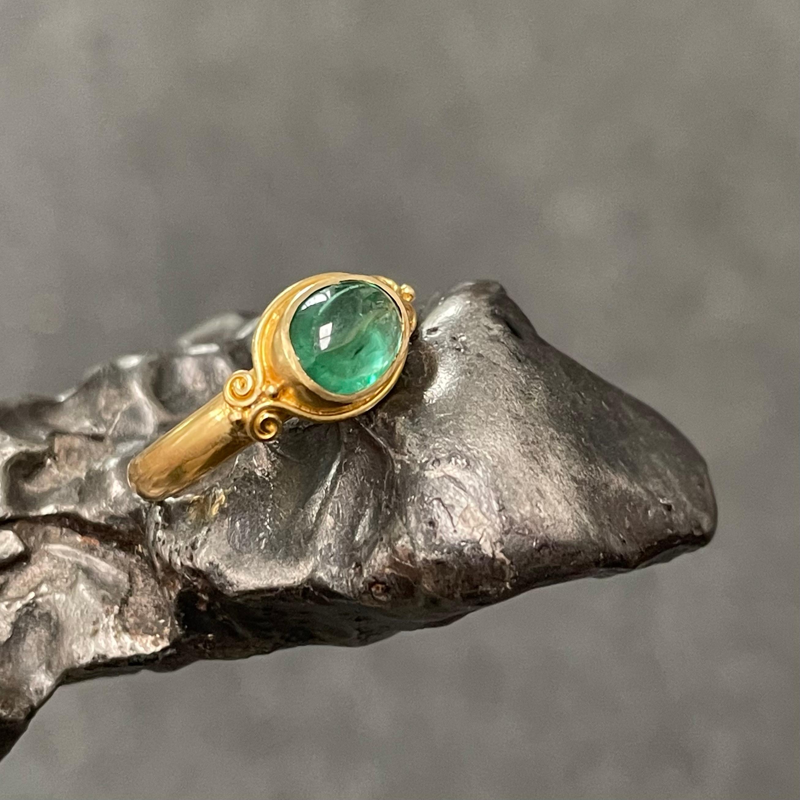 A lively, translucent, 6 x 8 mm Zambian emerald cabochon is held in a signature handmade 