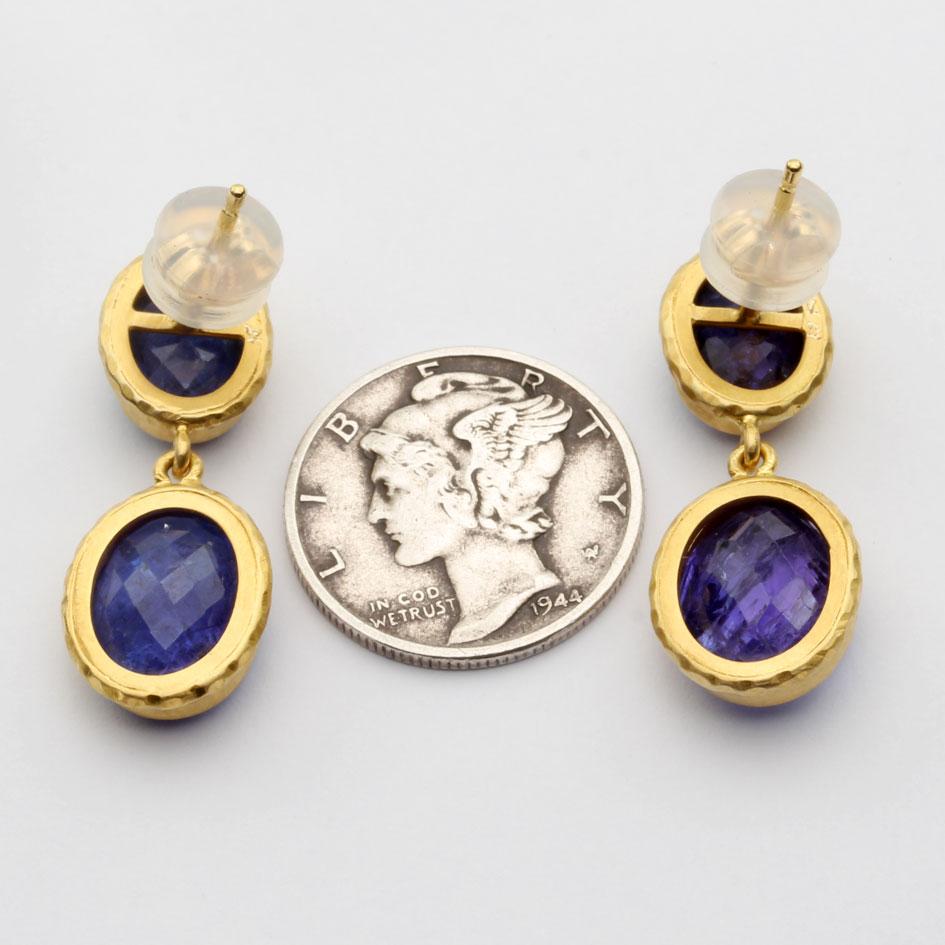 Des tanzanites ovales de 8 x 10 mm, taillées en briolette et bien assorties, sont entourées d'un double chaton en or 18 carats à la texture riche et pendent au-dessous d'une monture similaire en or 18 carats.  Des tanzanites de 6 x 8 mm dans ces