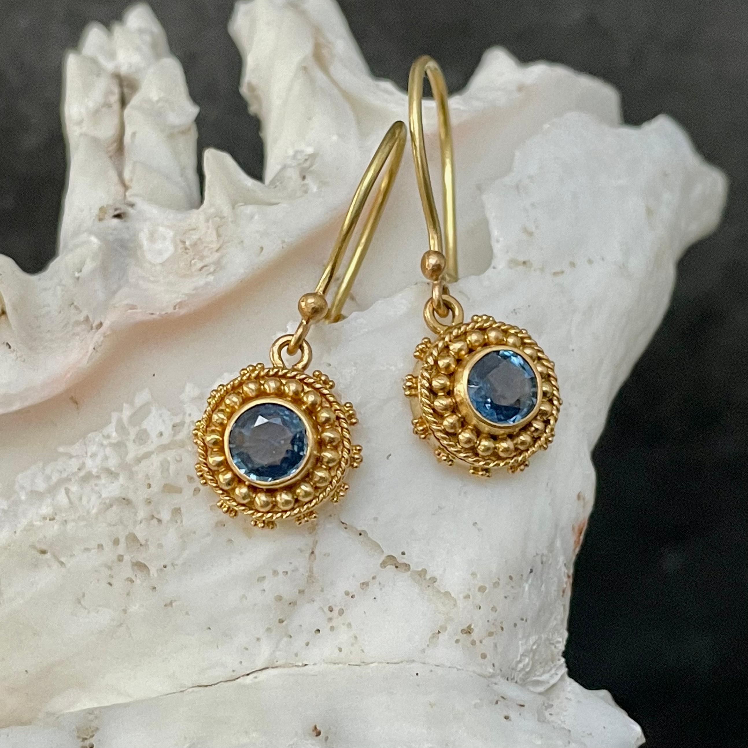 Two 5 mm faceted round blue sapphires are set in delicate handmade high karat granulated settings in this exquisitely classic design.  The radiating circles of gold 