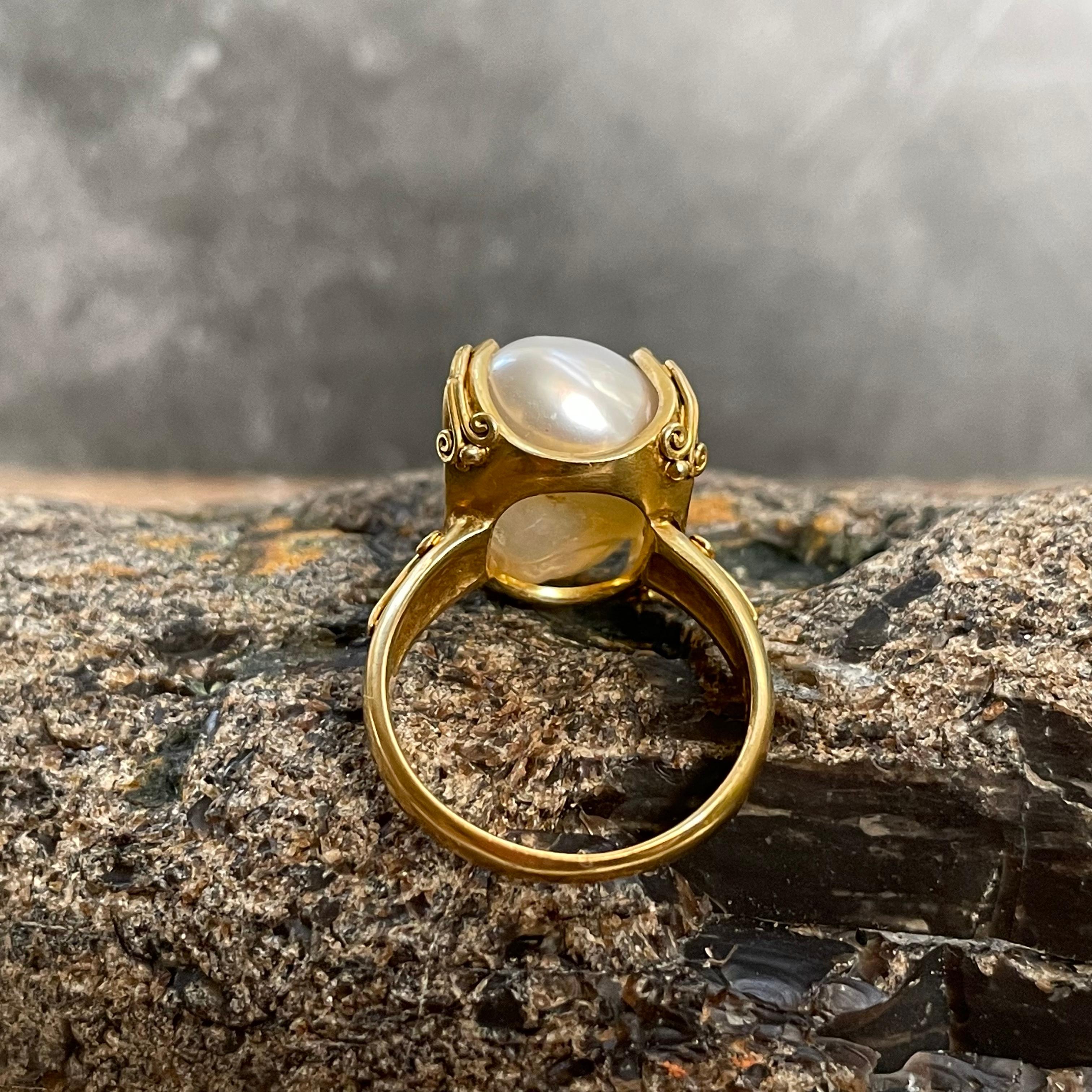 A lustrous, irregular, 9 x 15 mm white keshi pearl is held in four spiral wire ornamented prongs with a similar motif on the shank.  A great way to display this fantastic pearl.  All set within matte-finish gold. This ring is currently sized 6.  It