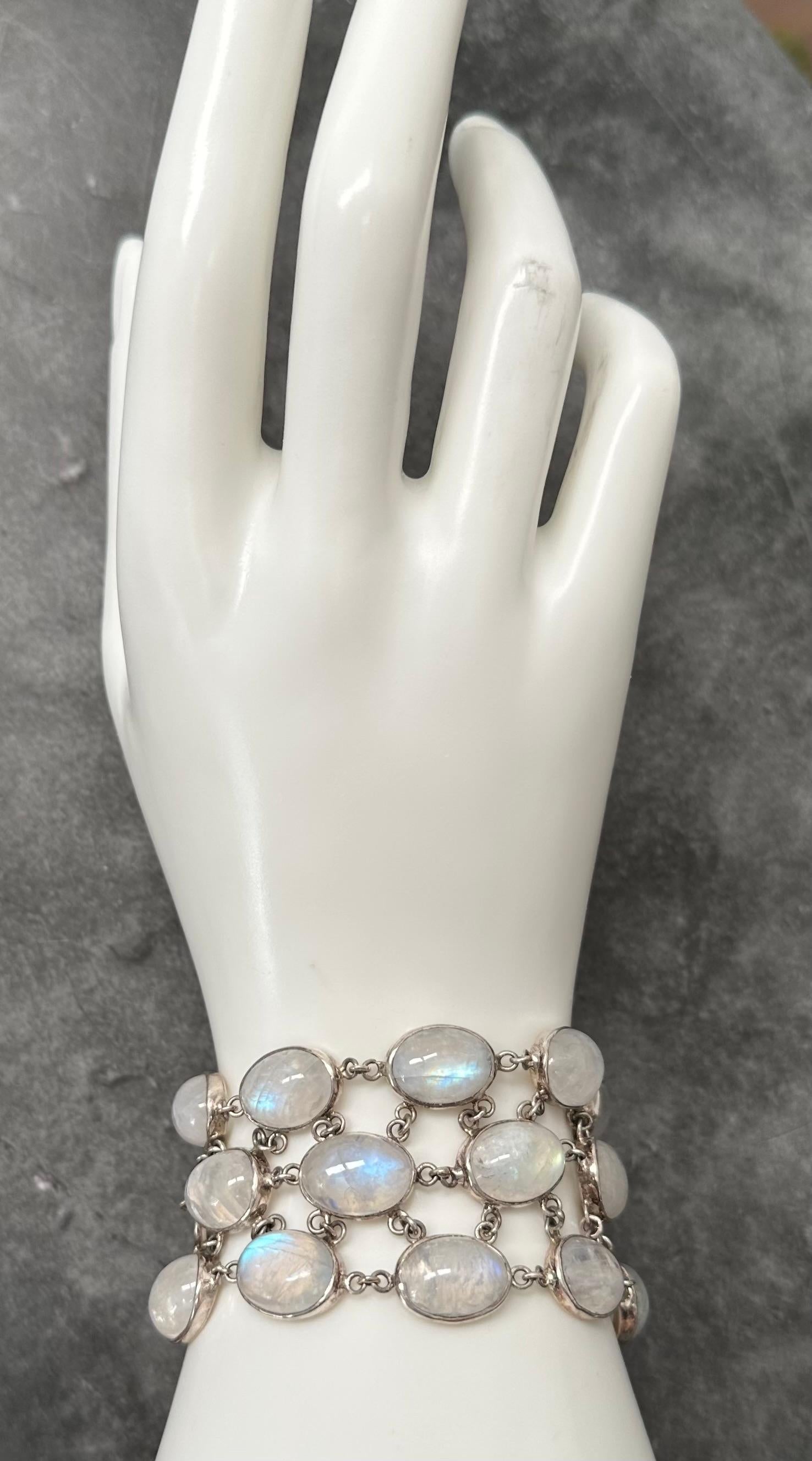Twenty large 10 x 14 mm oval cabochons of blue sheen rainbow moonstones are arranged in 3 offset linkages in simple handmade bezels in this one of a kind bracelet.  Each stone is attached to the others nearby via multiple jump rings to fit