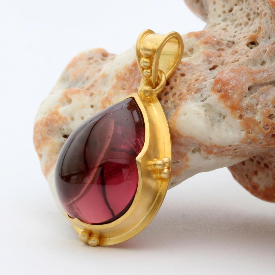 Un cabochon di tormalina rosa brasiliana di alta qualità, molto chiaro e vivace, di 12 x 17 mm a forma di pera, è racchiuso in un castone artigianale a 