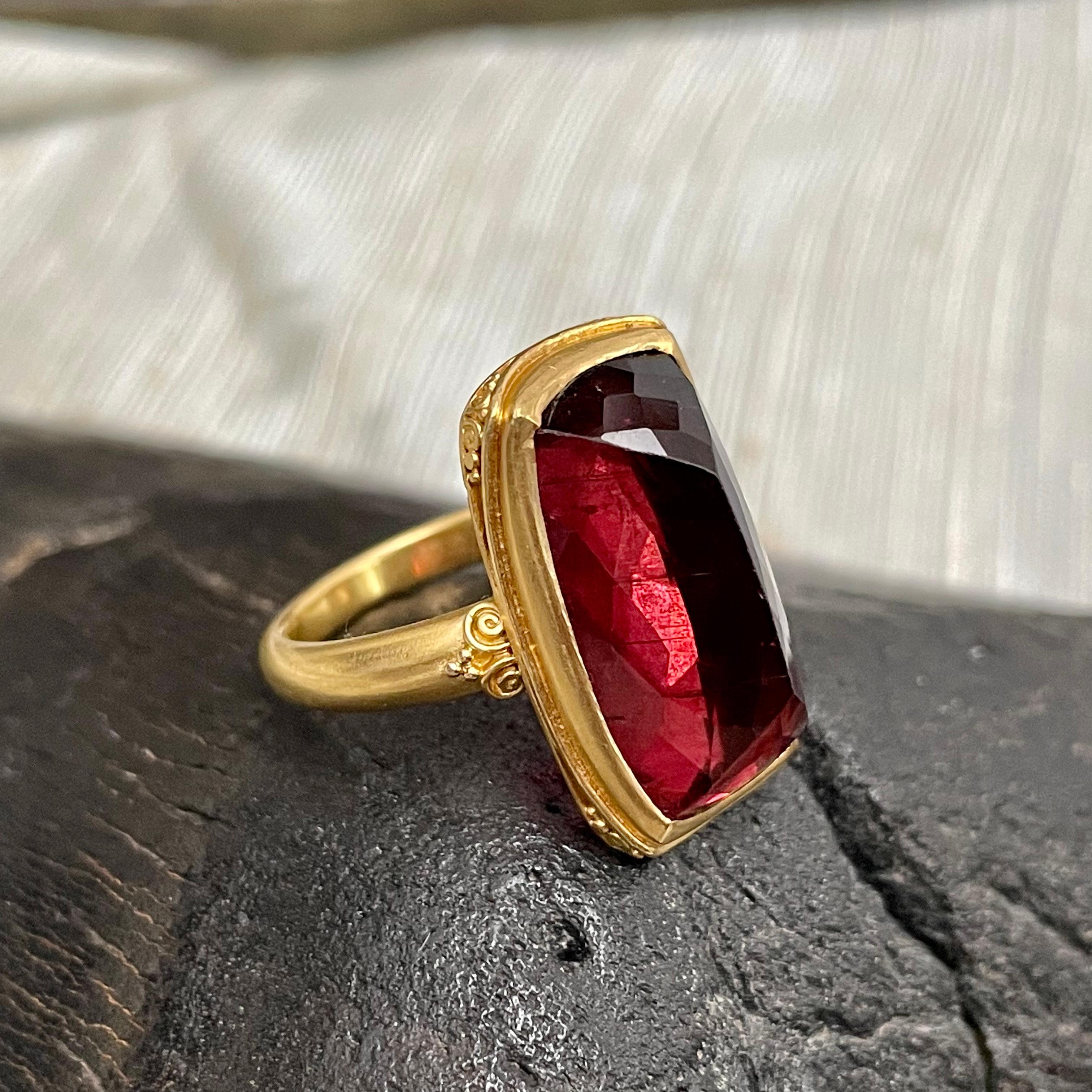 A juicy long cushion cut 14 x 32 mm pink tourmaline is set into a signature ancient-inspired Steven Battelle handmade 22K design featuring spiral and 