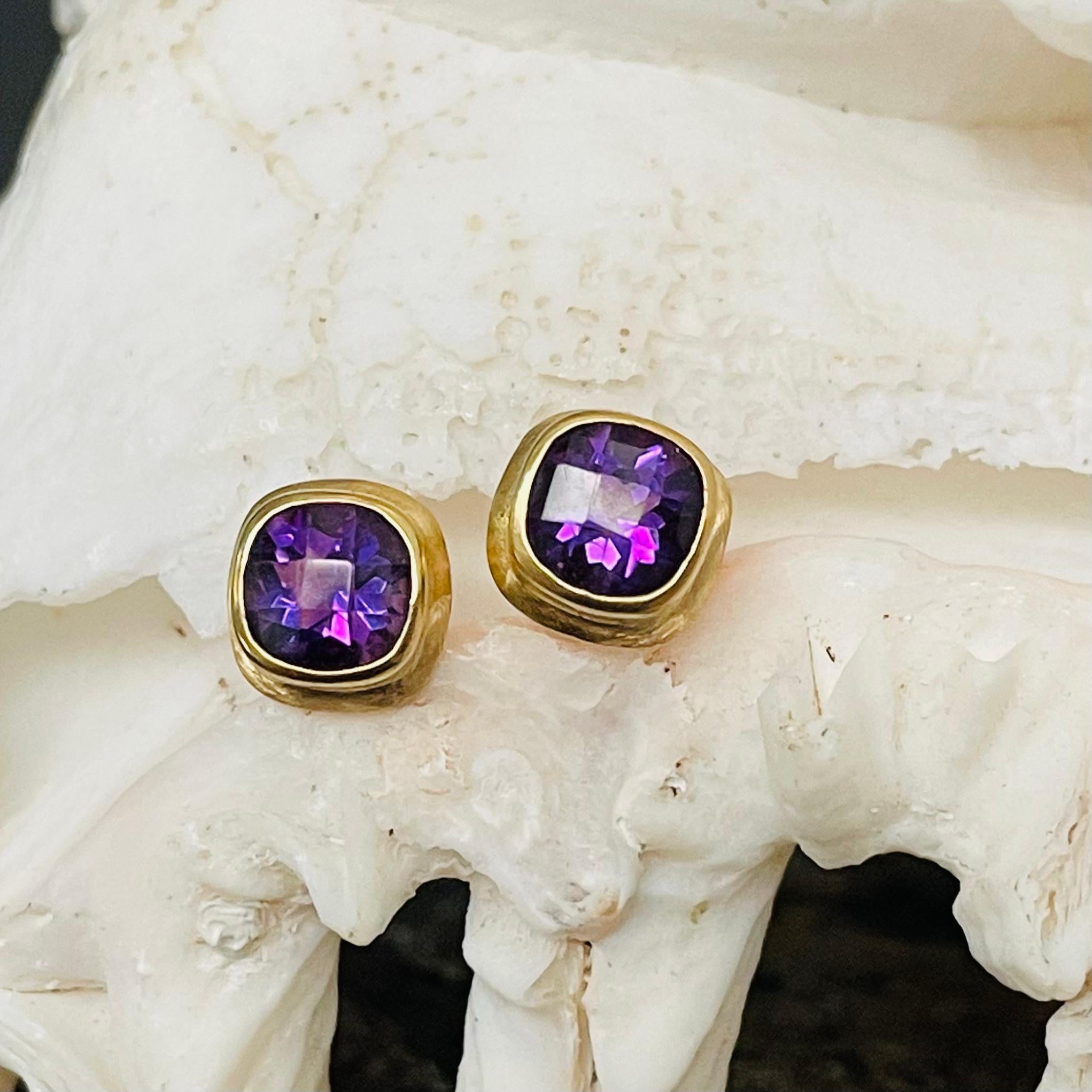 Two 5 mm cushion checkerboard faceted deep purple African amethysts are held in classic basic settings with slightly textured matte double bezels surrounding in these ultimately simple yet attractive posts.   A nice splash of color for your day!