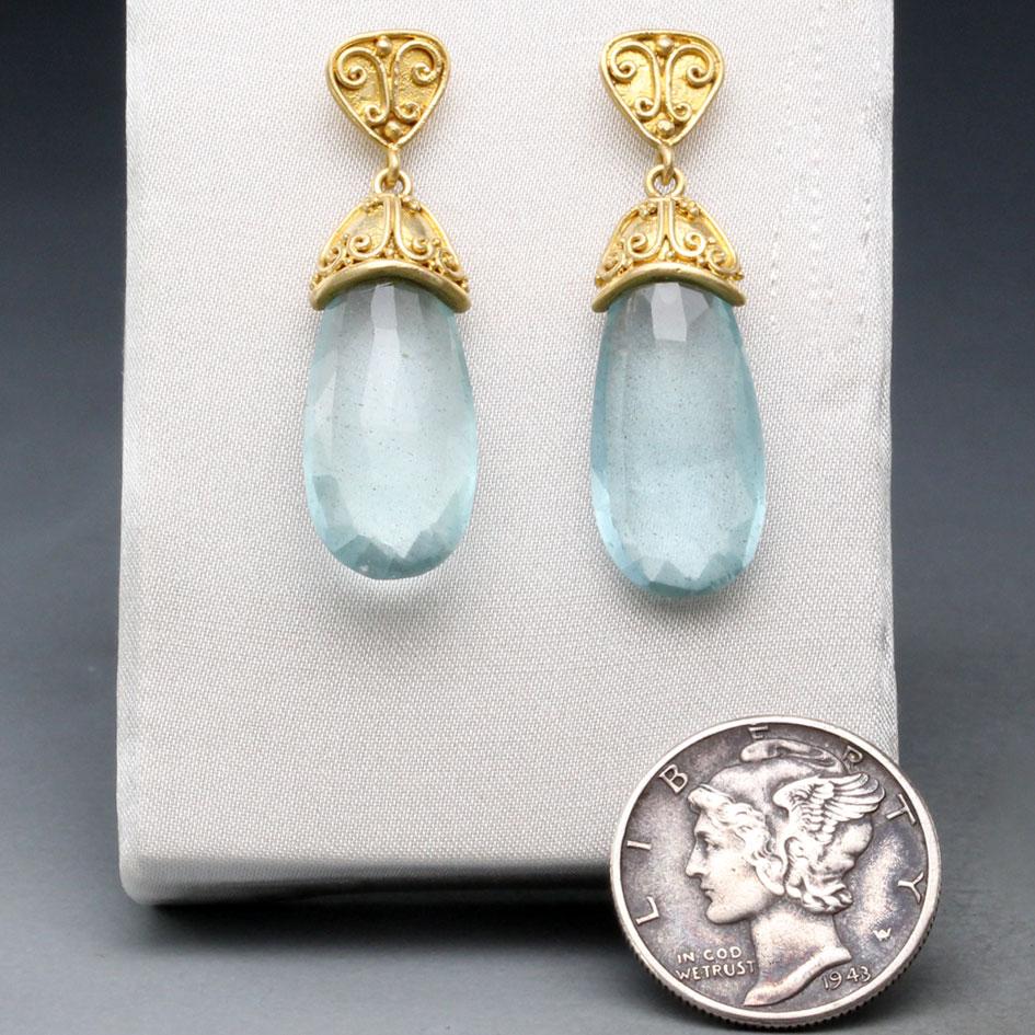 Two 9 x 20 mm long pear shaped faceted aquamarines are set within handmade 18K end-caps with wire and 