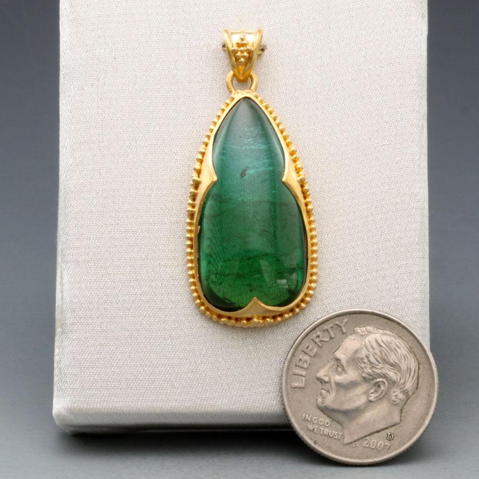 A long pear shaped 12 x 24 mm tourmaline cabochon ranges from sea blue at the top to a rich green at the bottom.  This interesting gemstone is set in an ancient-inspired 