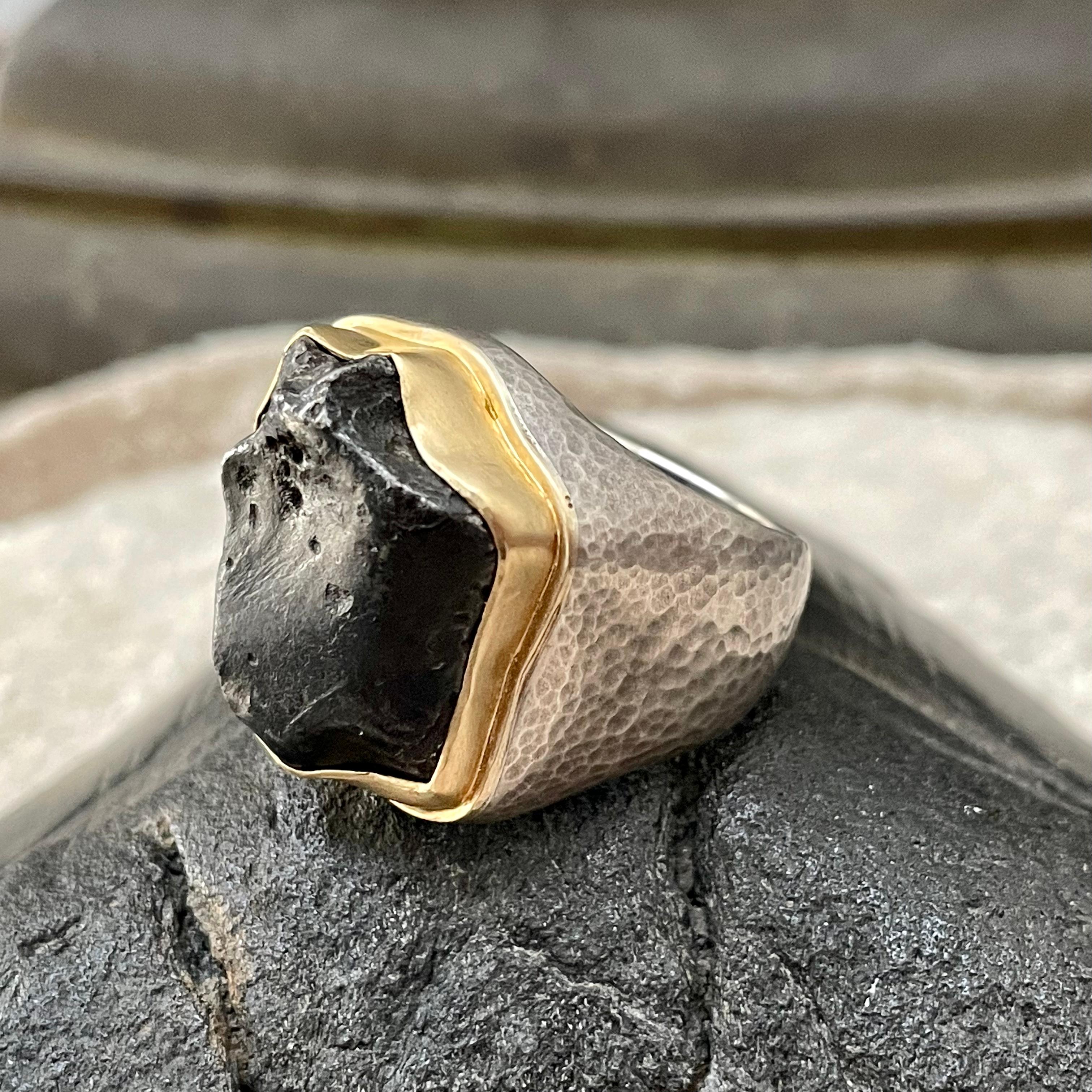 An individual irregular fragment (19 x 23 mm, 14.6 grams) of Sinkote-Alin meteorite with a fusion crust from its flaming entry through the atmosphere is set in aheavy 18K gold bezel with added 18K double bezel in an individually custom formed heavy