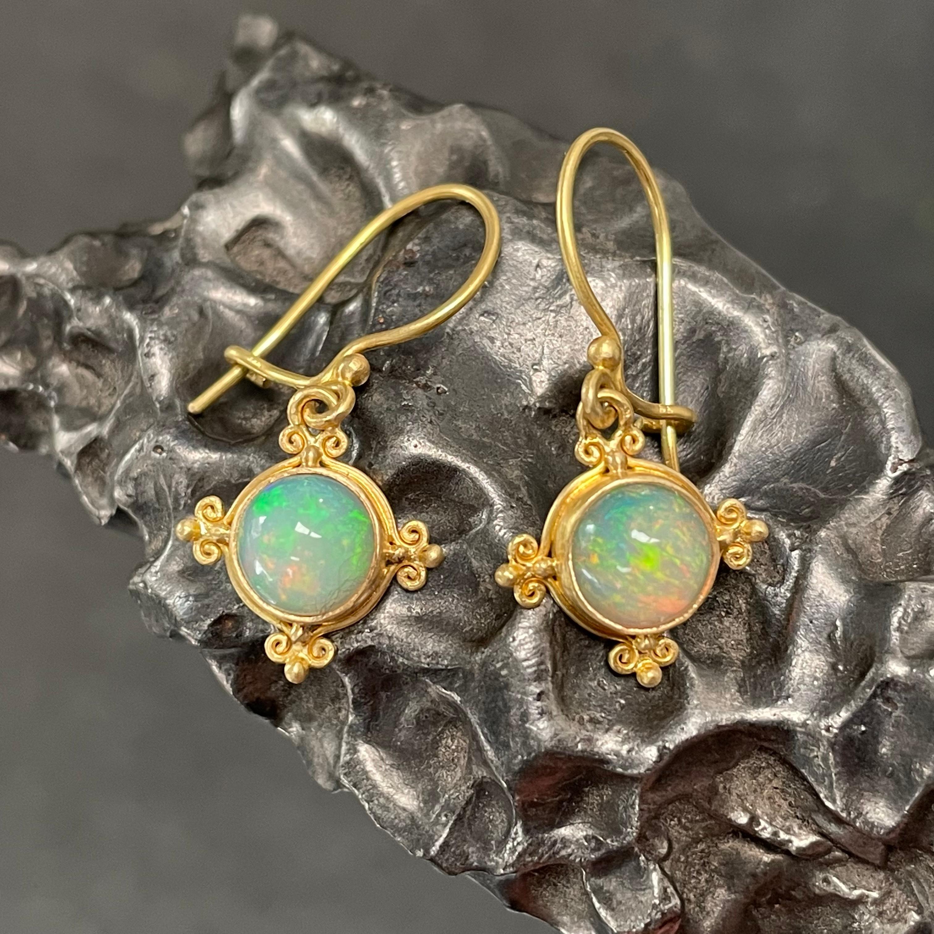Deux cabochons ronds de 7 mm d'opale éthiopienne de la mine Welo, joliment assortis, sont sertis dans une délicate monture en or 18 carats de type 