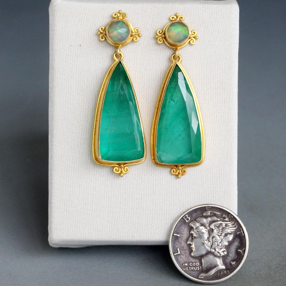 Two large and luscious triangular cut 10 x 22 mm emeralds from the Itabira mines in Minas Gerais, Brazil, dangle below 5 mm round rose faceted Ethiopian opal studs in these enchanting, probably unrepeatable, 18K gold earrings. The opals are