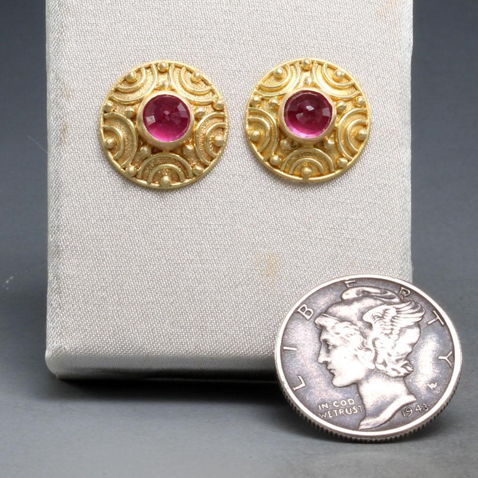 Two vibrant 5mm rose faceted pink rubies are set within a handmade 18K gold domed 