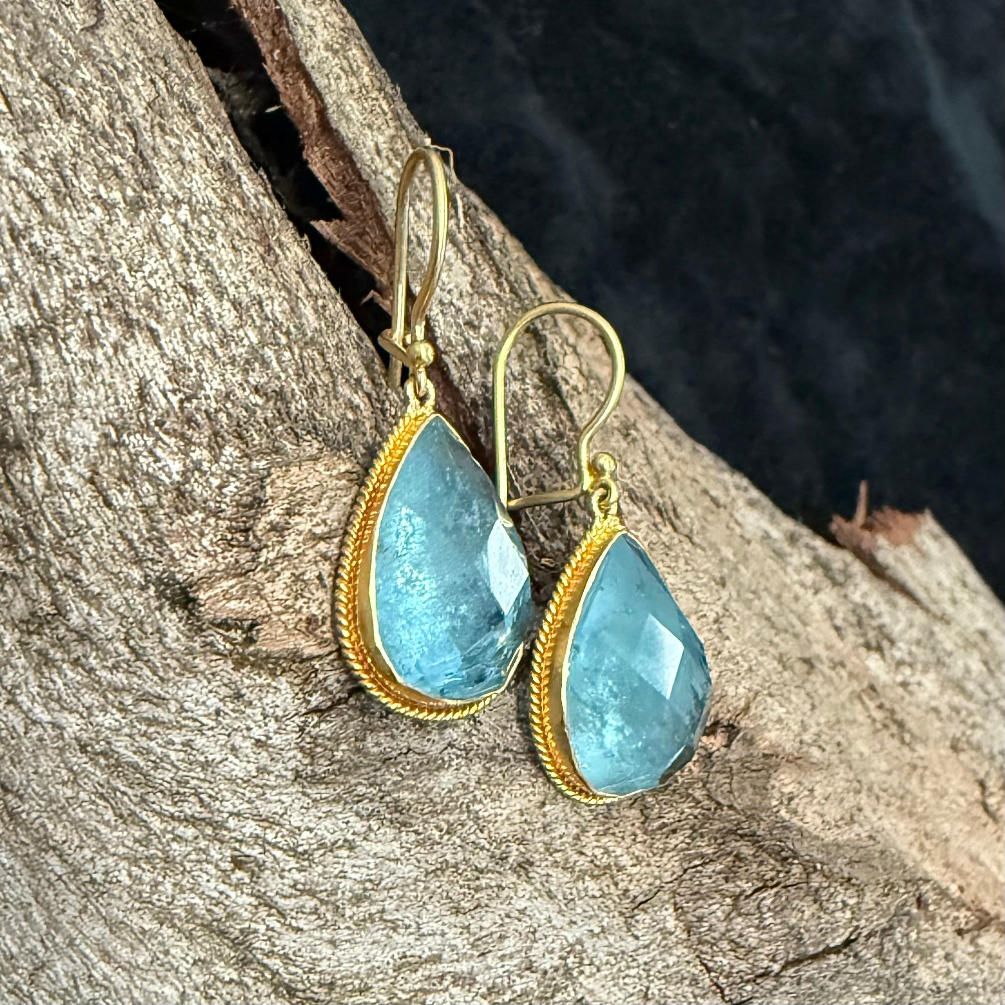 Due acquemarine a forma di pera di 11 x 17 mm, ben abbinate, sono circondate da castoni in oro 18 carati lavorati artigianalmente e sospesi sotto fili di sicurezza 18 carati in questi orecchini. Bella la semplicità delle pietre, non c'è bisogno di