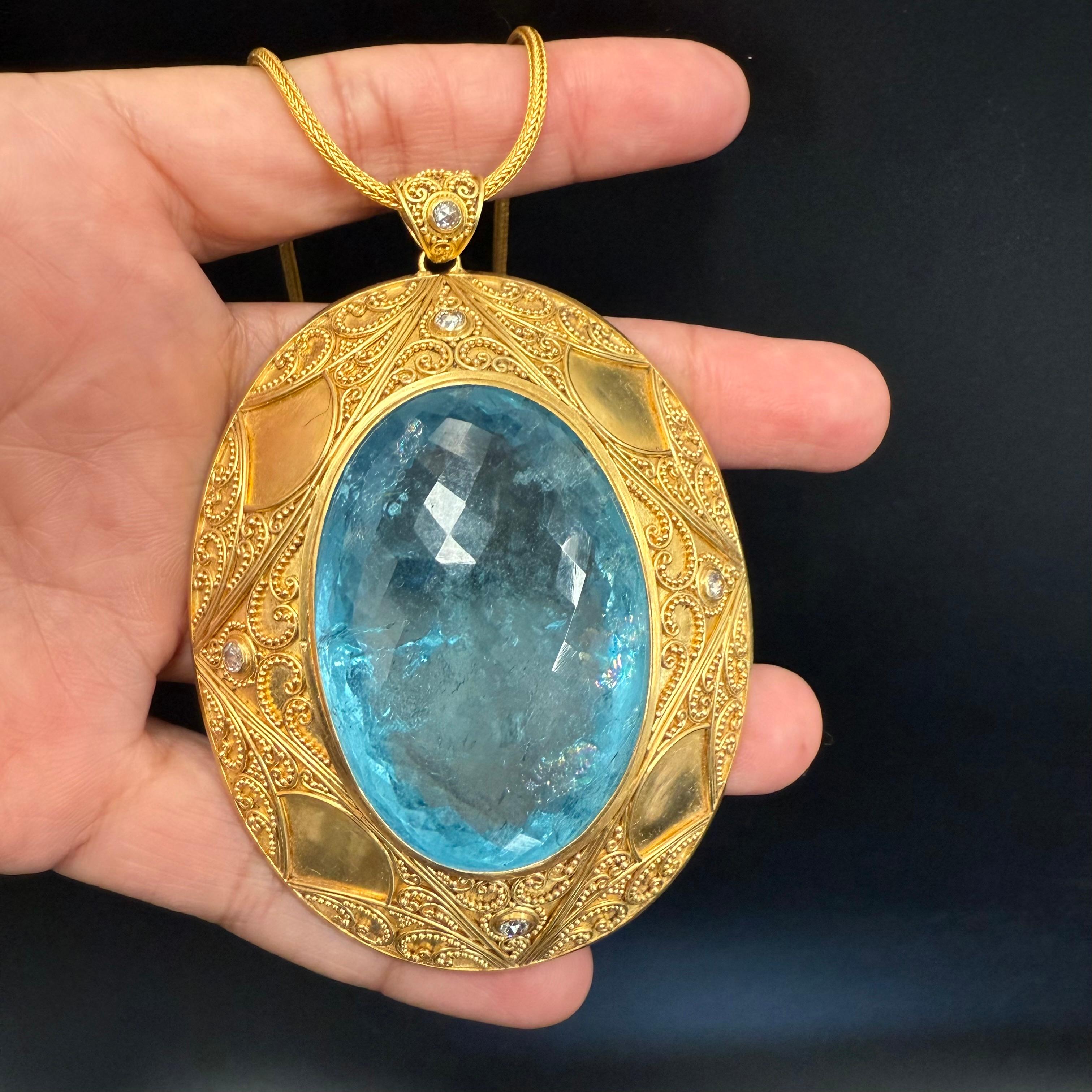 Une aigue-marine brésilienne ovale à facettes de 30 x 50 mm est la pièce maîtresse de ce chef-d'œuvre unique. 182,3 carats au total. Cette pierre étonnante est sertie dans une large monture granulée à haute teneur en or avec cinq diamants VS1 de 2