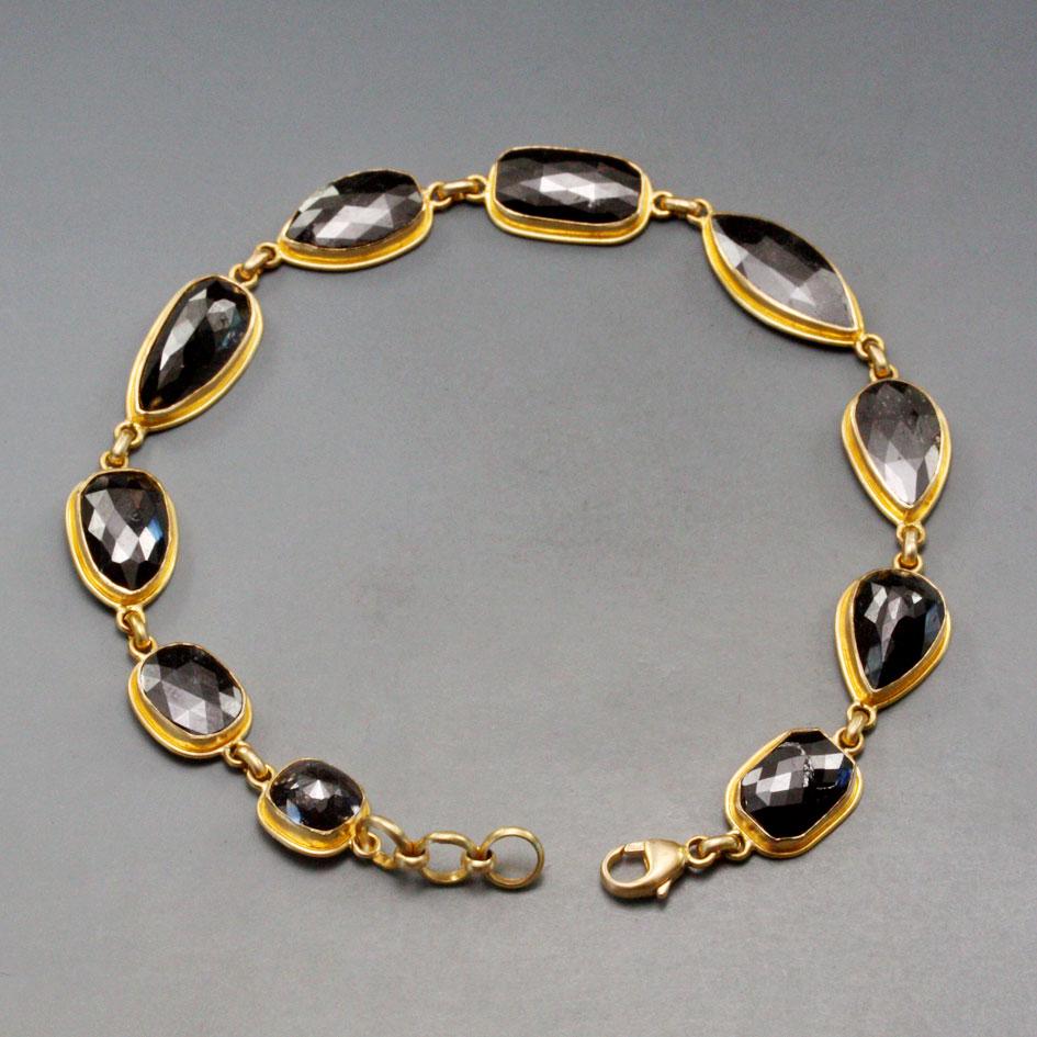 Ten uniquely shaped rose cut black diamonds from 1 to 3 carats in size are combined with rich matte-finish 18K gold double bezels in this simple, yet classic, bracelet design.  This bracelet can be adjusted between 7 to 71/2 inches depending on