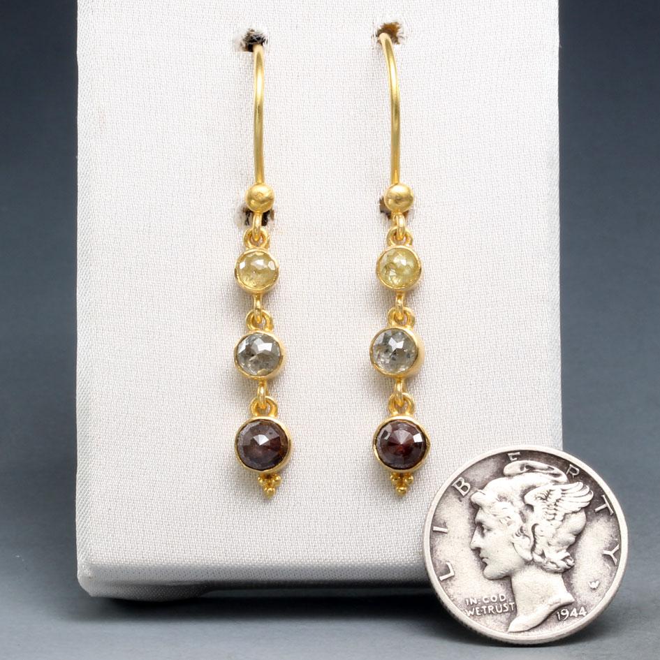 Three multicolored rose-faceted natural diamonds of yellow (3 mm), grey (4 mm) and brown (5 mm) coloration are set in simple 18K gold matte-finish bezels and dangle below 18K safety-clasp ear wires with a small circular orb at the join in this