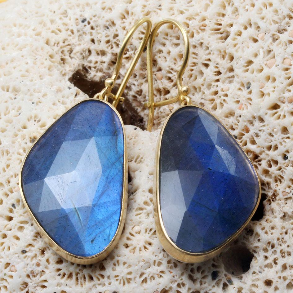 Two large, 16 x 28 mm, semi-triangular pieces of brilliant blue-flashing rose-cut labradorite set in matte-finish 18K gold bezels glisten below safety-clasp 18K gold ear wires in these eye-catching earrings.  The backs (not visible) of the earrings