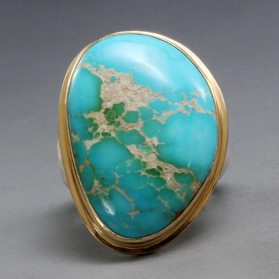 A beautifully variegated 19 x 26 mm cabochon of Kingman Mine Arizona turquoise is set in an 18K gold bezel with matte-finish surrounding 18K double bezel below, all atop a hammered and tapered matte-finish sterling silver shank. A simple and classic