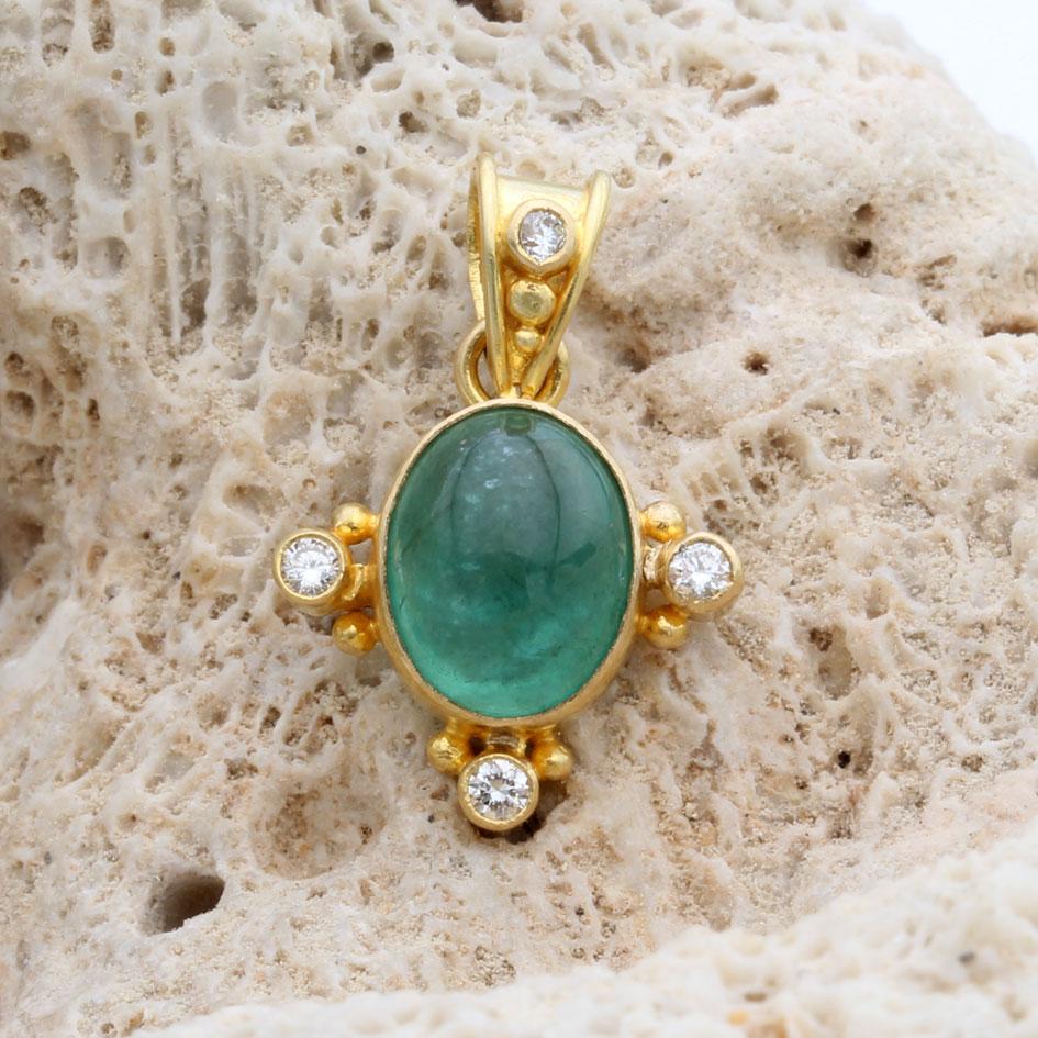 Un succoso smeraldo ovale cabochon dello Zambia di 7 x 9 mm riposa in un castone in oro 18 carati lavorato artigianalmente, circondato da diamanti VS1 di 1,9 mm con doppia granulazione 