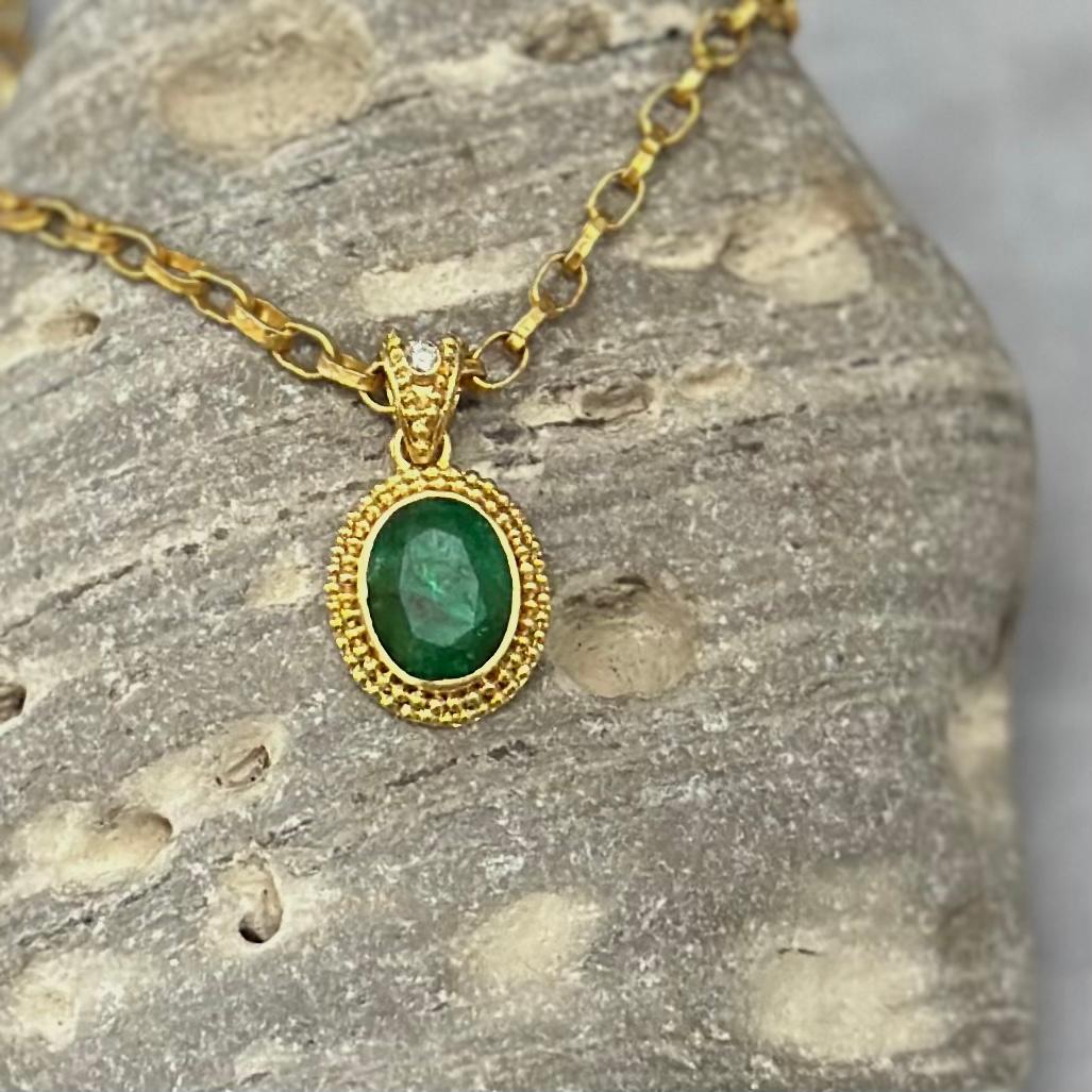 An 8 x 10 mm oval faceted Zambian emerald is set in a classic ancient-inspired 