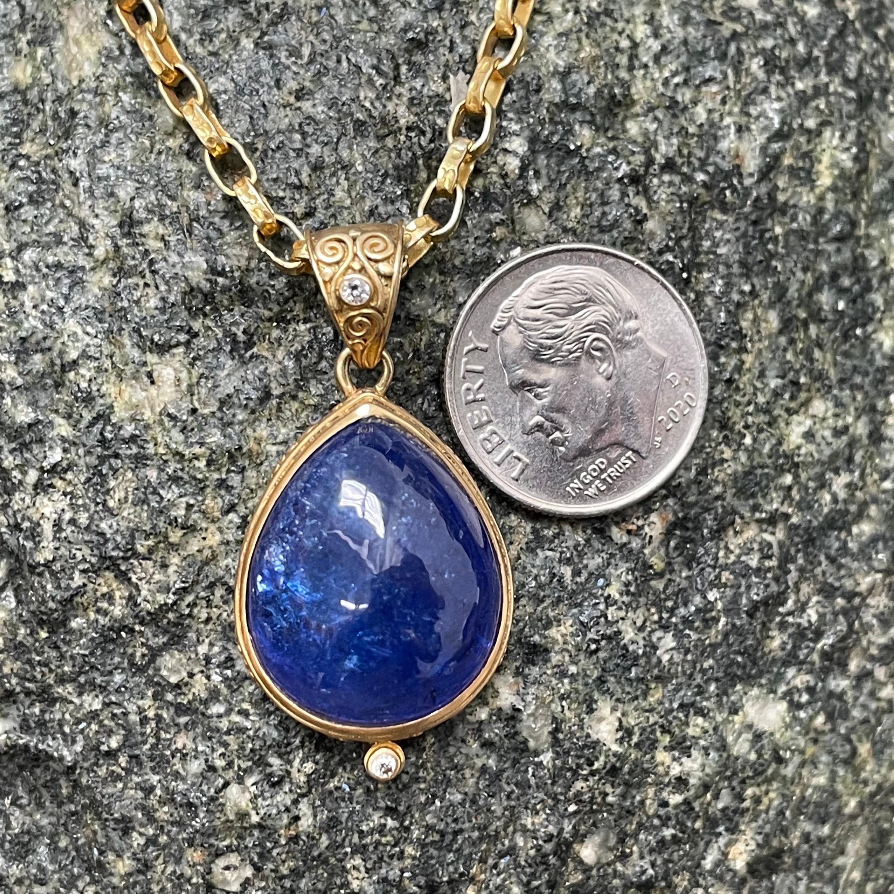 A beautiful blue 23 x 30 mm pear shaped tanzanite cabochon is held in a cupped Steven Battelle designed pendant with spiral scroll accenting on the bezel.  A similar scrolled bail is highlighted by a 1.8 mm VS1 diamond.  Sweet!  The 18K handmade