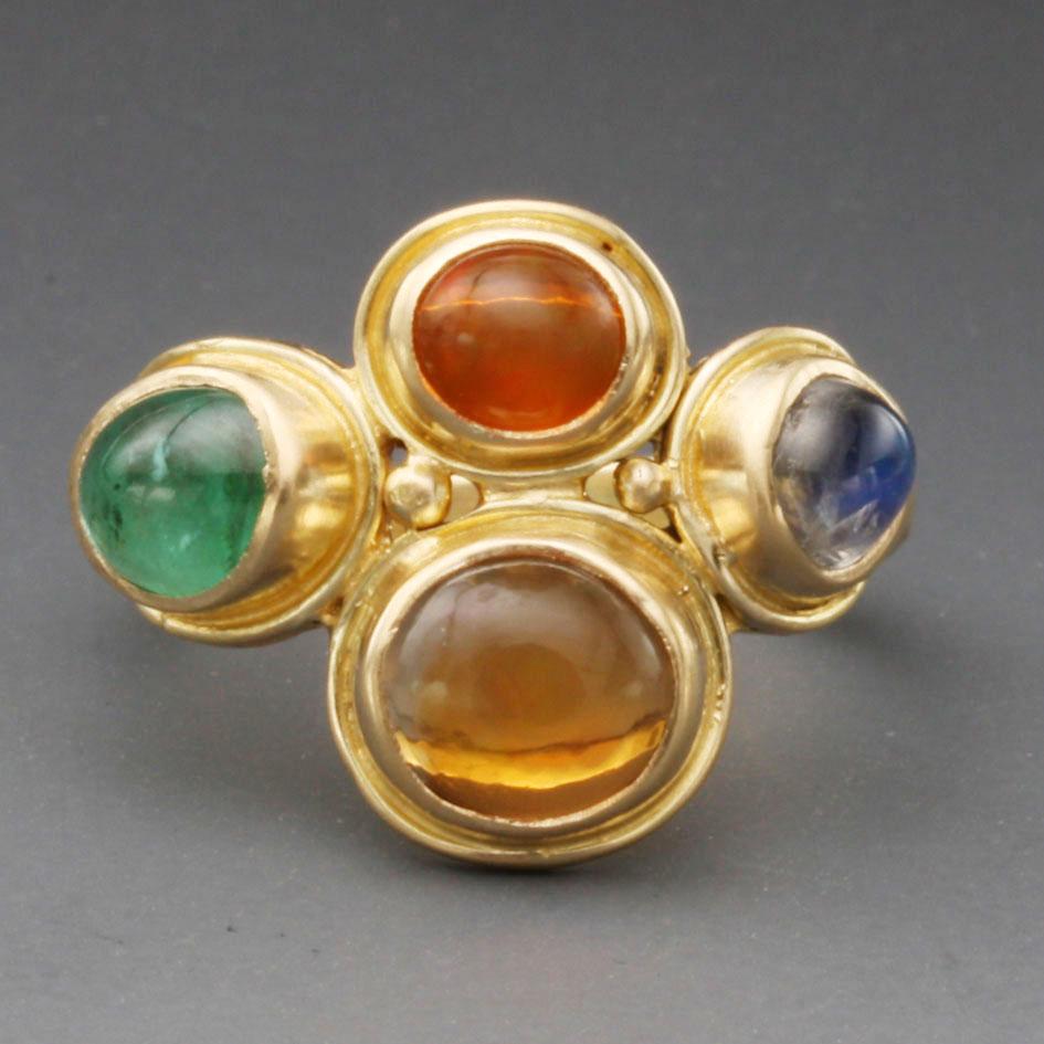 A fanciful assortment of 7x9 mm Mexican fire opal, 5x7 mm emerald, and 2 approximately 5mm
cabochons of a deeper shape of fire opal and shimmering blue rainbow moonstones are arranged together with two 
