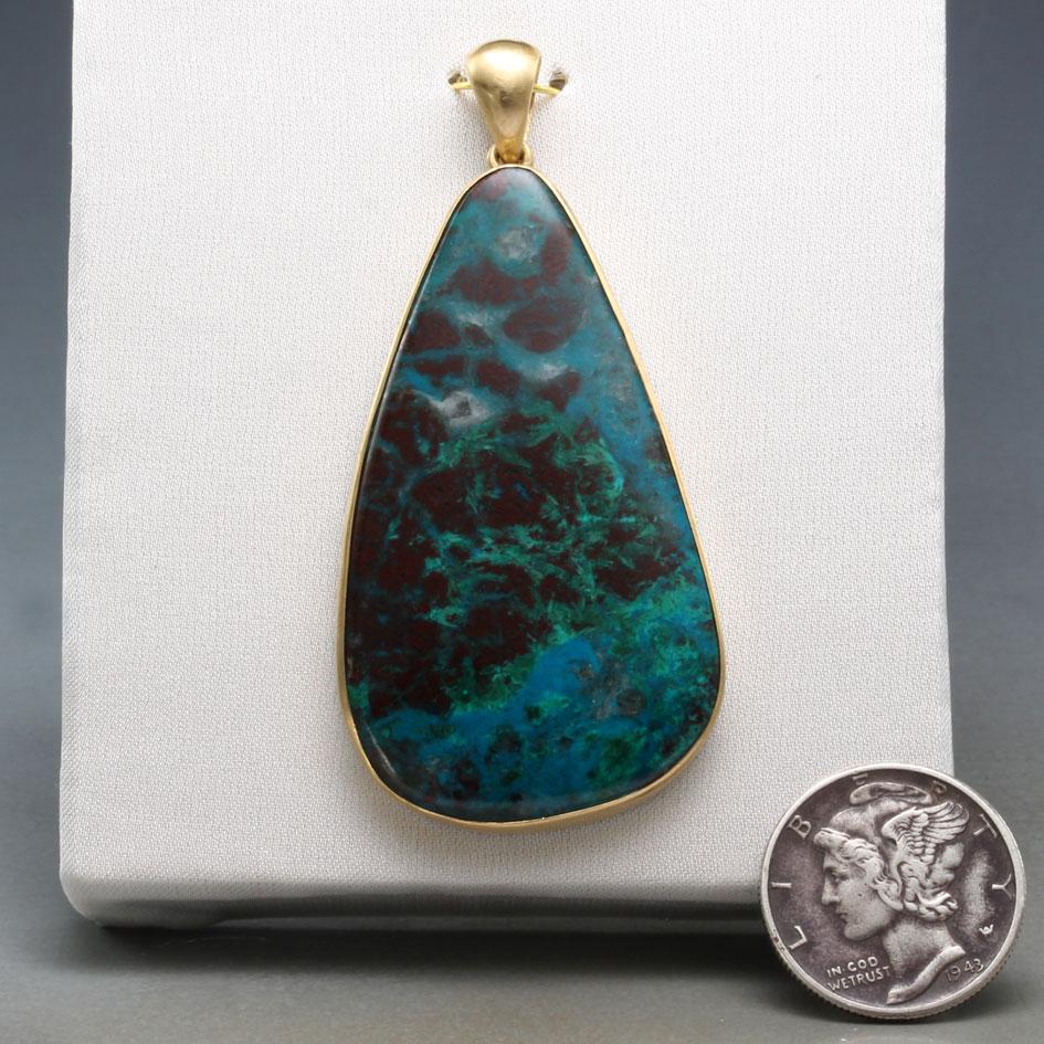 A beautifully variegated 25 x 45 mm pear shaped cabochon of Indonesian blue opal is simply set in matte-finish 18K gold in this ultimately simple and classic piece.  Indonesian blue opal is a type of petrified wood from the island of Java, which can