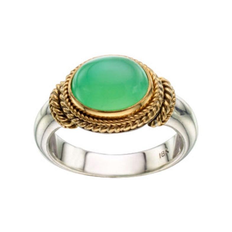 Un luminoso cabochon di crisoprasio australiano verde lime di 8 x 10 mm poggia orizzontalmente in un abbraccio di 