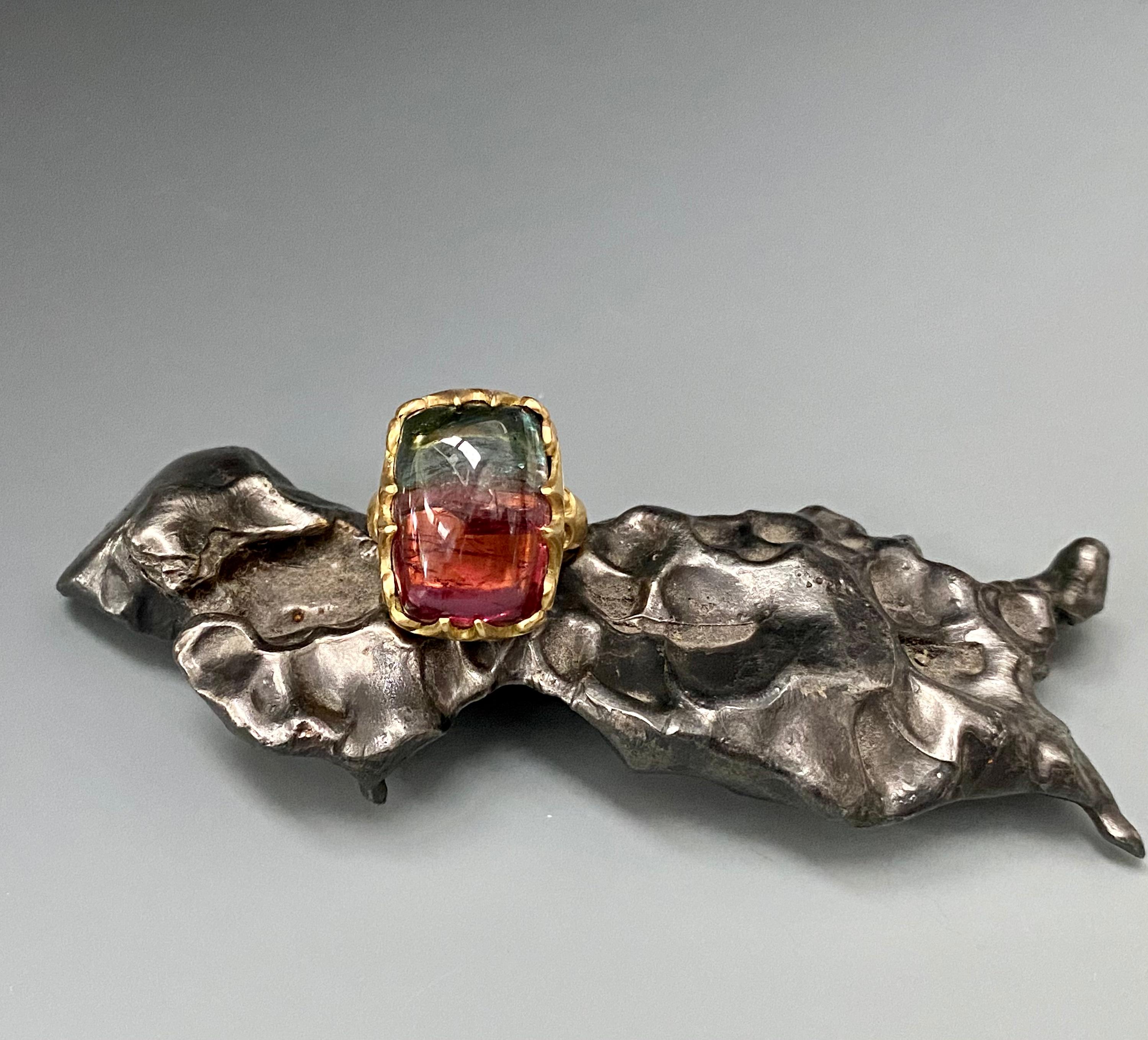 A deep reddish pink to green 17 x 23 mm Brazilian watermelon tourmaline cushion cabochon is held in multiple carved wide fluted 