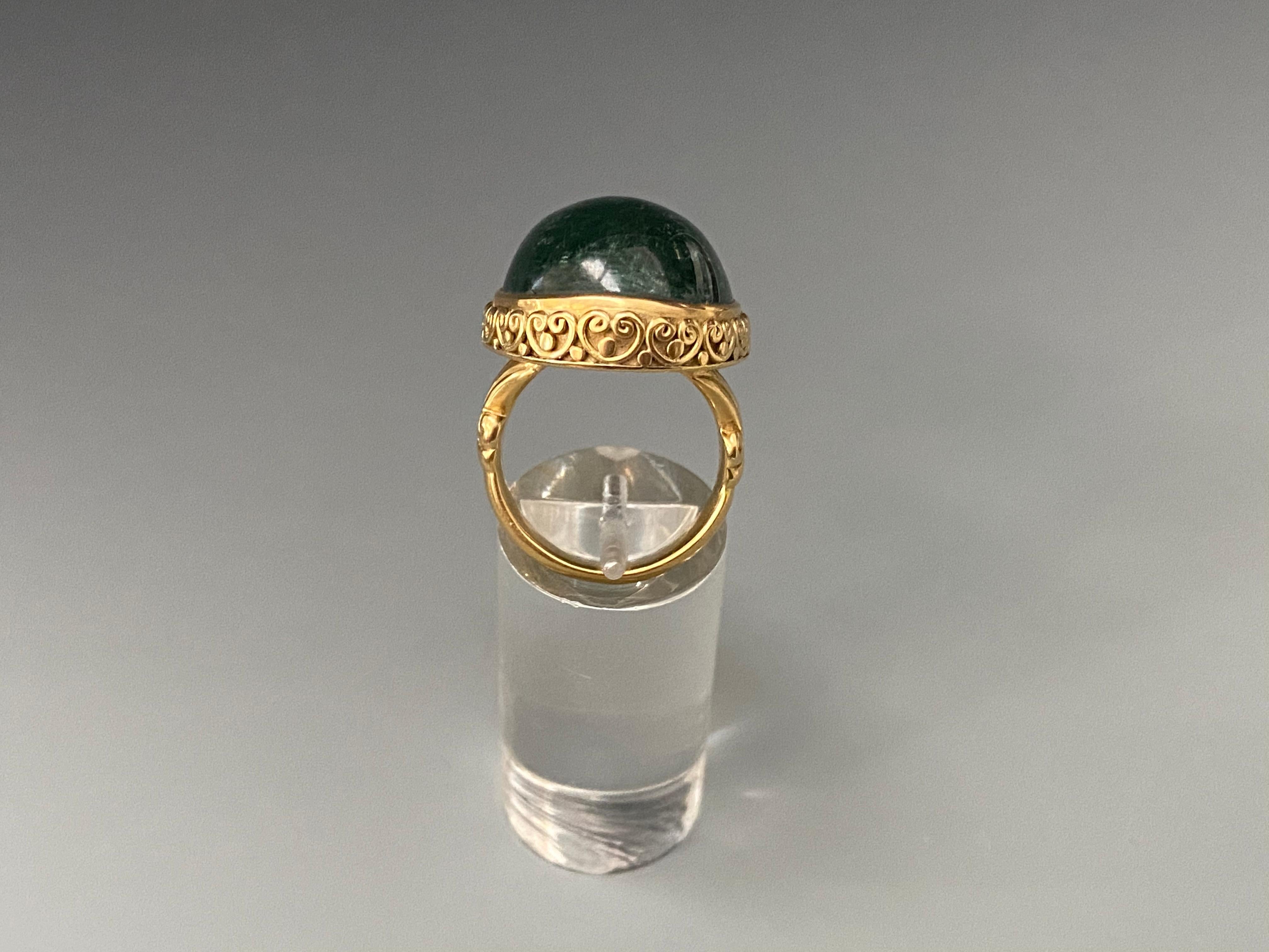 A large beautiful blue-green tourmaline oval cabochon accompanied with hand soldered delicate spiral bezel accents will be an object of admiration for the owner of this ring.   Currently size 7, but can be resized.  The stone is approximately