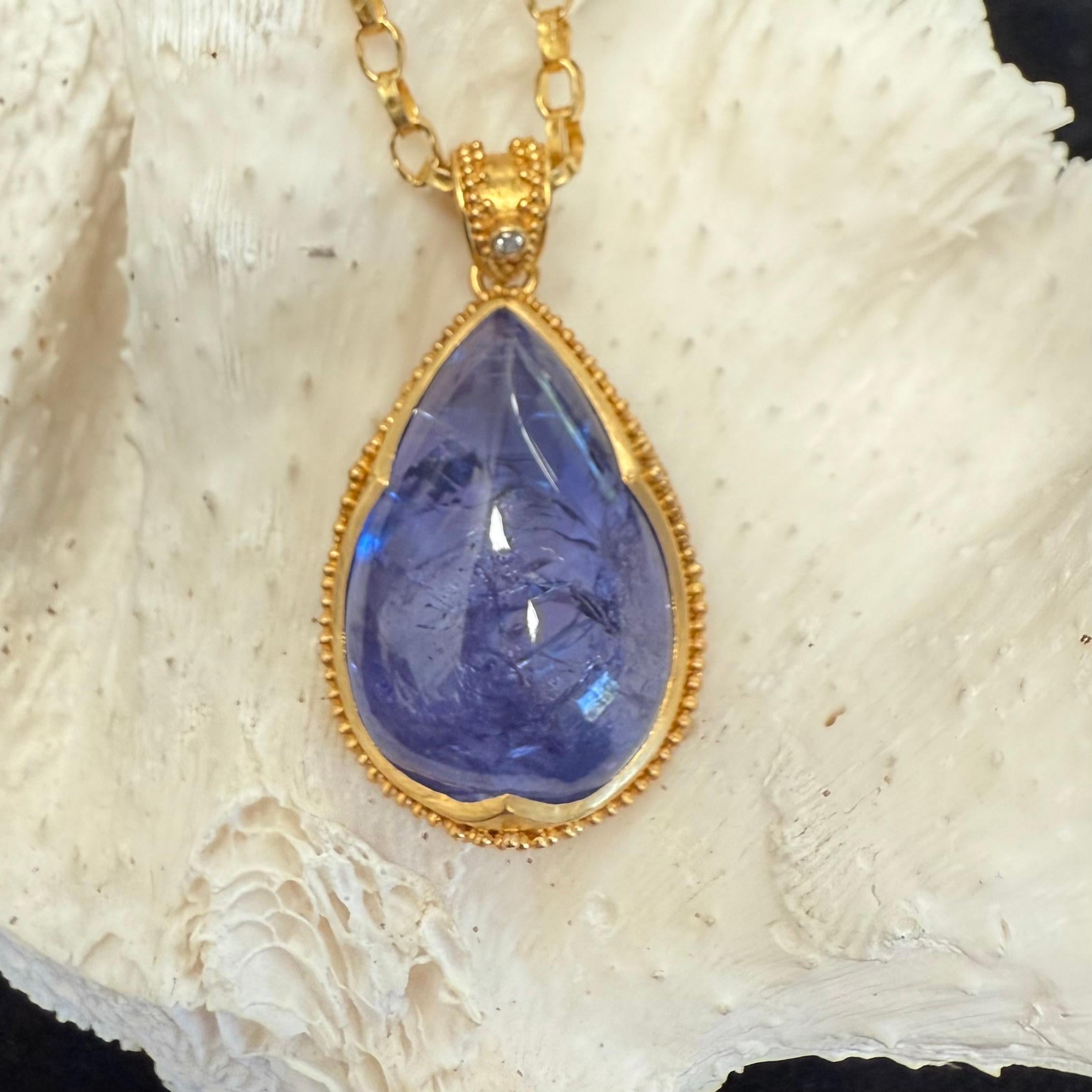A large, 17 x 26 mm, pear shaped cabochon tanzanite is set in a signature 