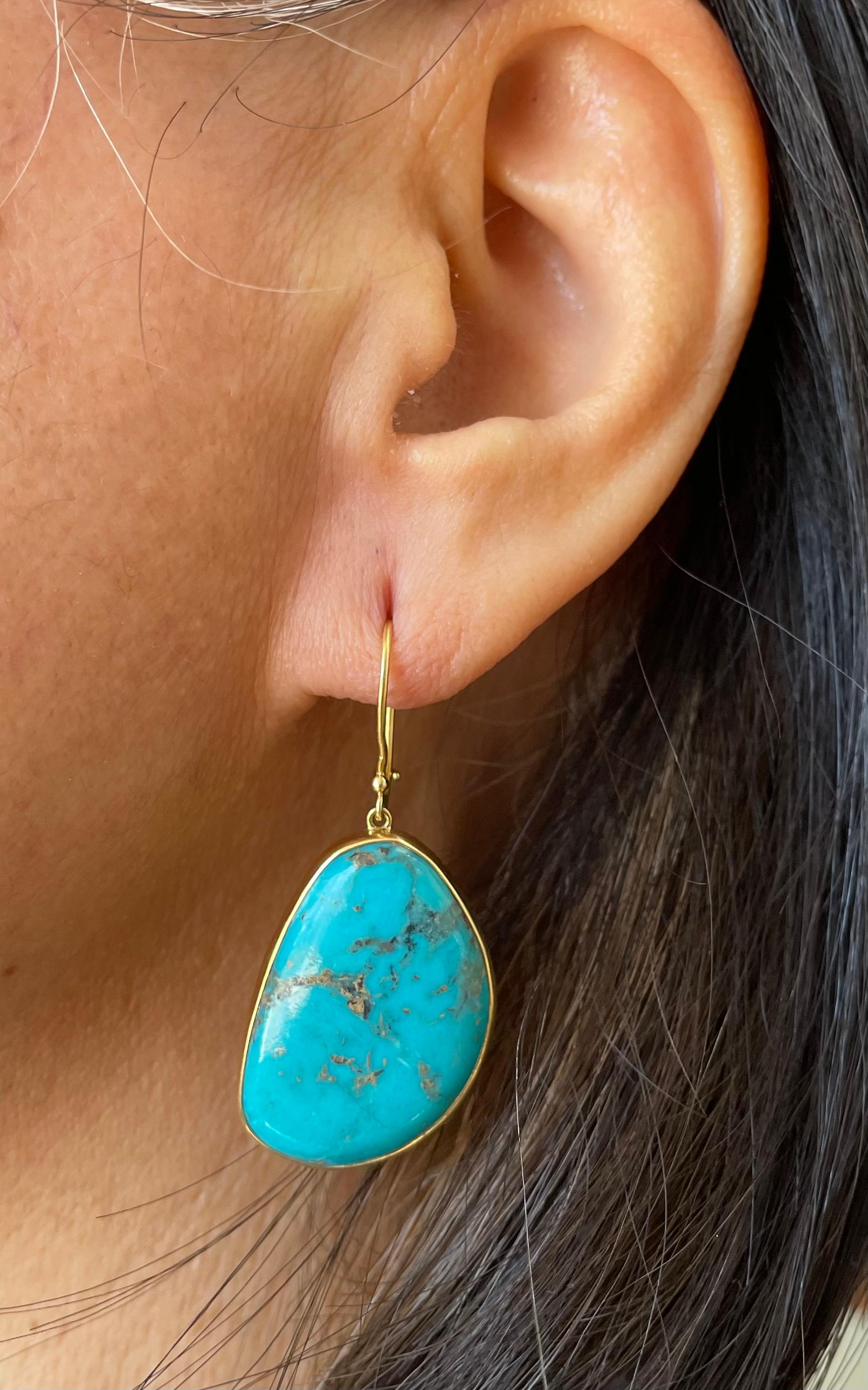Two large, 19 x 28 mm irregular shaped matched turquoise cabochons are held in simple 18K bezels below safety clasp wires.
A great look for a great price!  Kingman turquoise from Arizona.