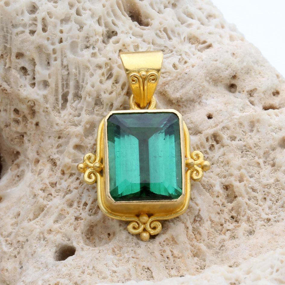 Un'accattivante e luminosa tormalina verde brasiliana di 8 x 10 mm è incastonata in una montatura artigianale in oro 18 carati 