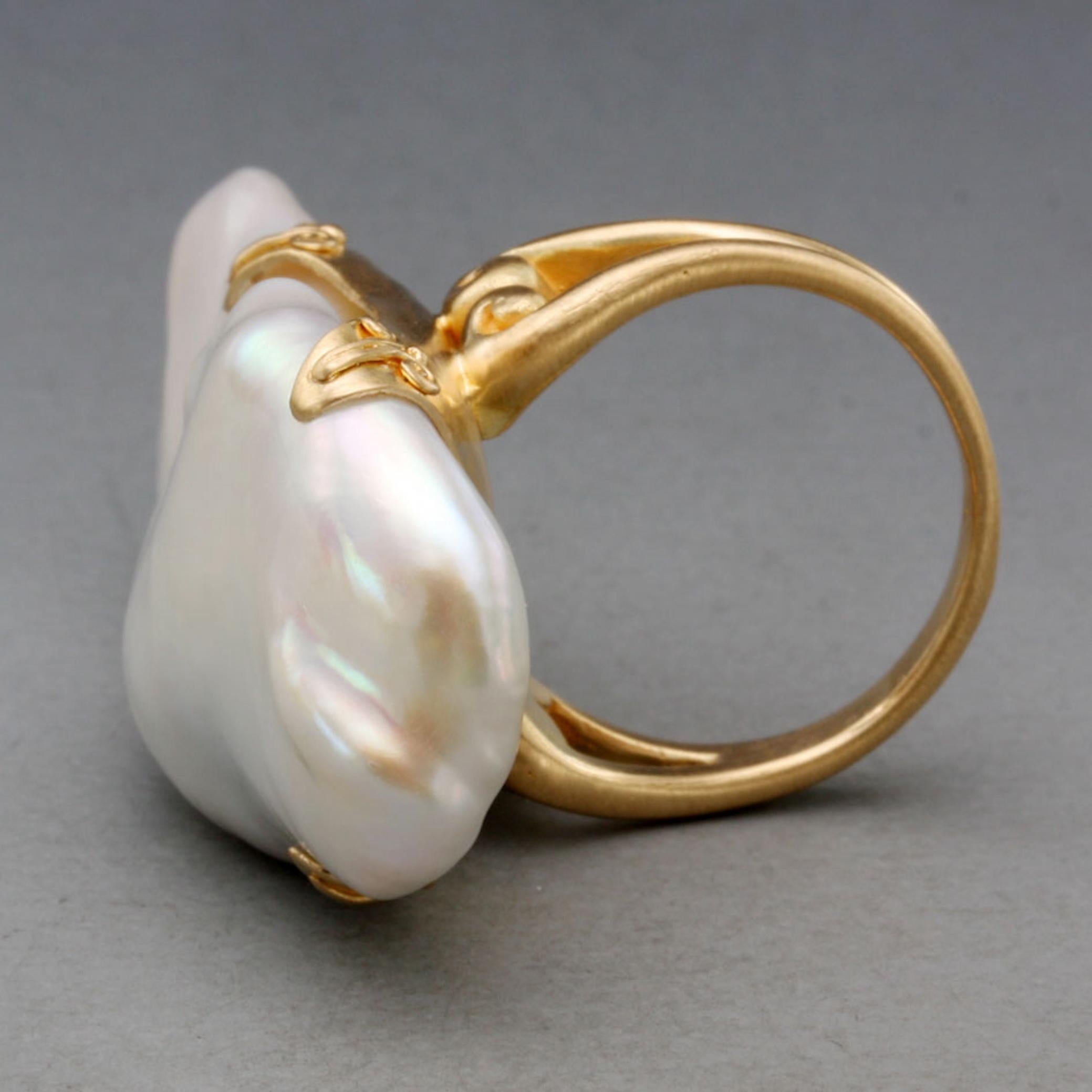 Une TRES grande (20x 42 mm) et lustrée perle d'eau douce blanche irrégulière est sertie dans une étreinte en or 18K à quatre branches avec des accents de fil en spirale sur les branches au sommet d'une intéressante 