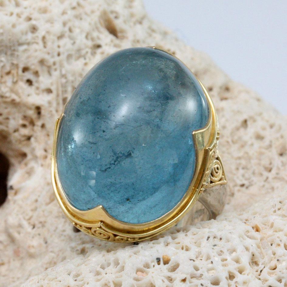 Un cabochon di acquamarina blu intenso a cupola alta, delle dimensioni di 18 x 24 mm, è custodito  longitudinalmente nella nostra firma 
