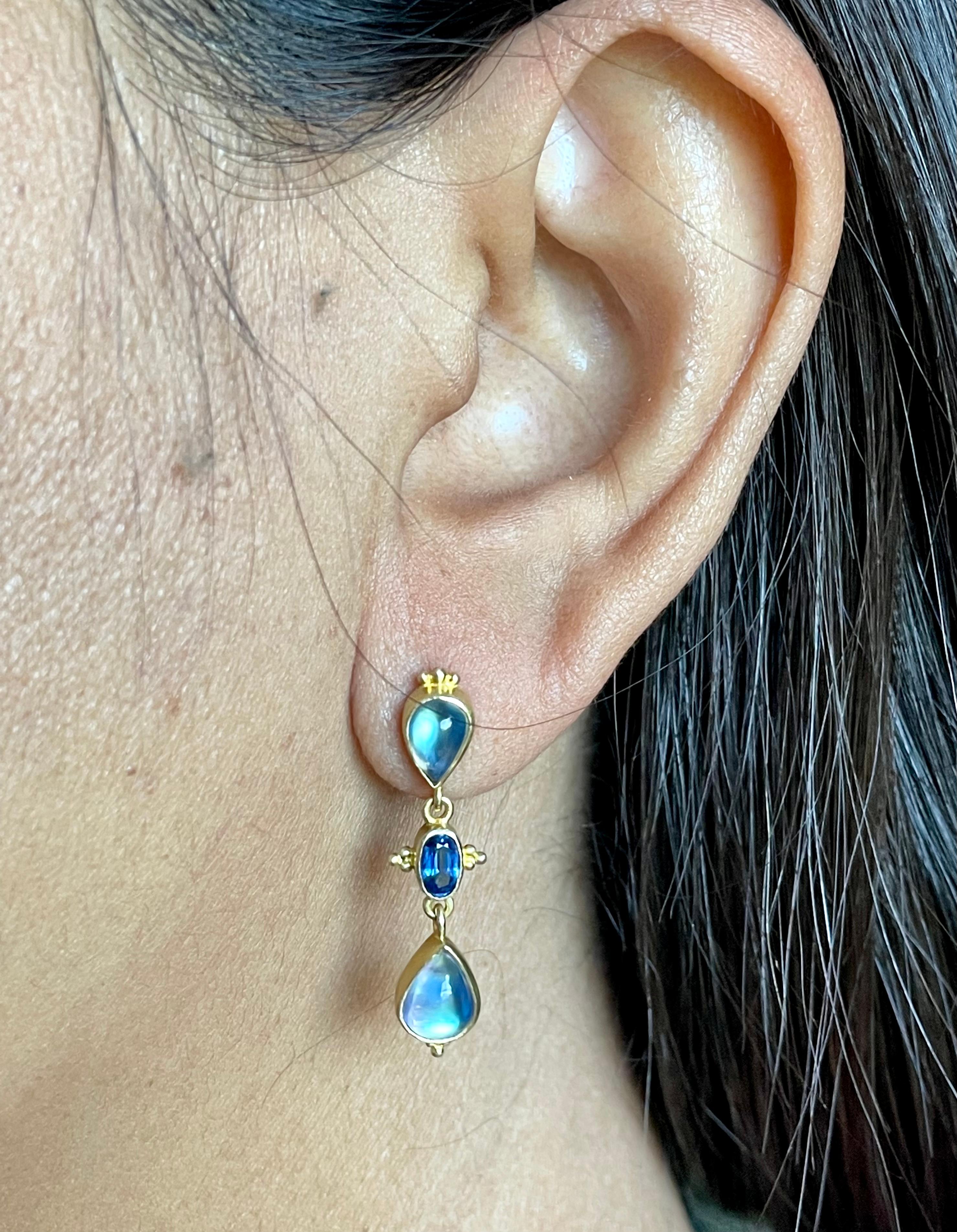 Matching shimmering 5 x 7 and 6 x9 mm pear shaped rainbow moonstones face away from each other with brilliant blue 3 x 5 mm faceted Kyanites suspended between in this wonderful design.  Small triangular granulation accents the symmetry. You will