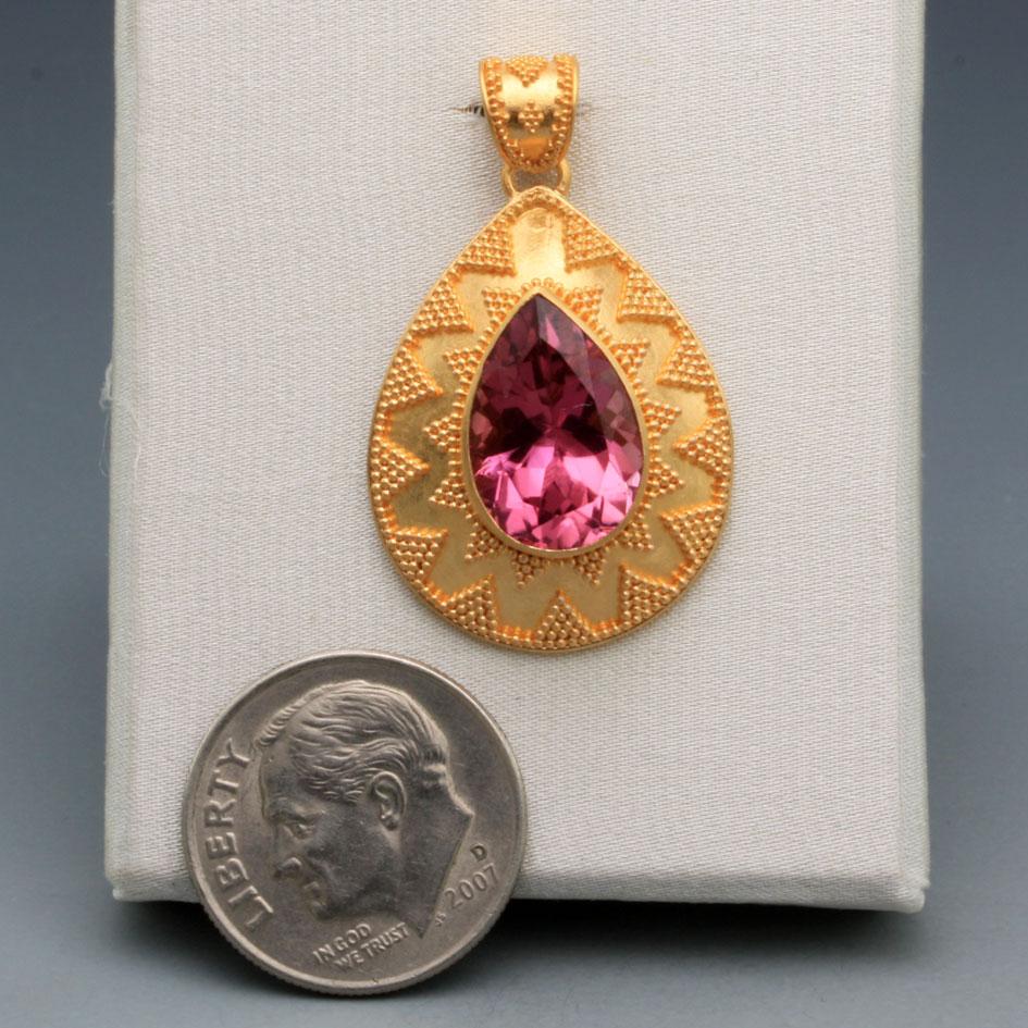 A sparkling, bright pink 9 x 12 mm pair shaped faceted Brazilian pink tourmaline is set in an exquisite artisan crafted stacked opposing geometric 