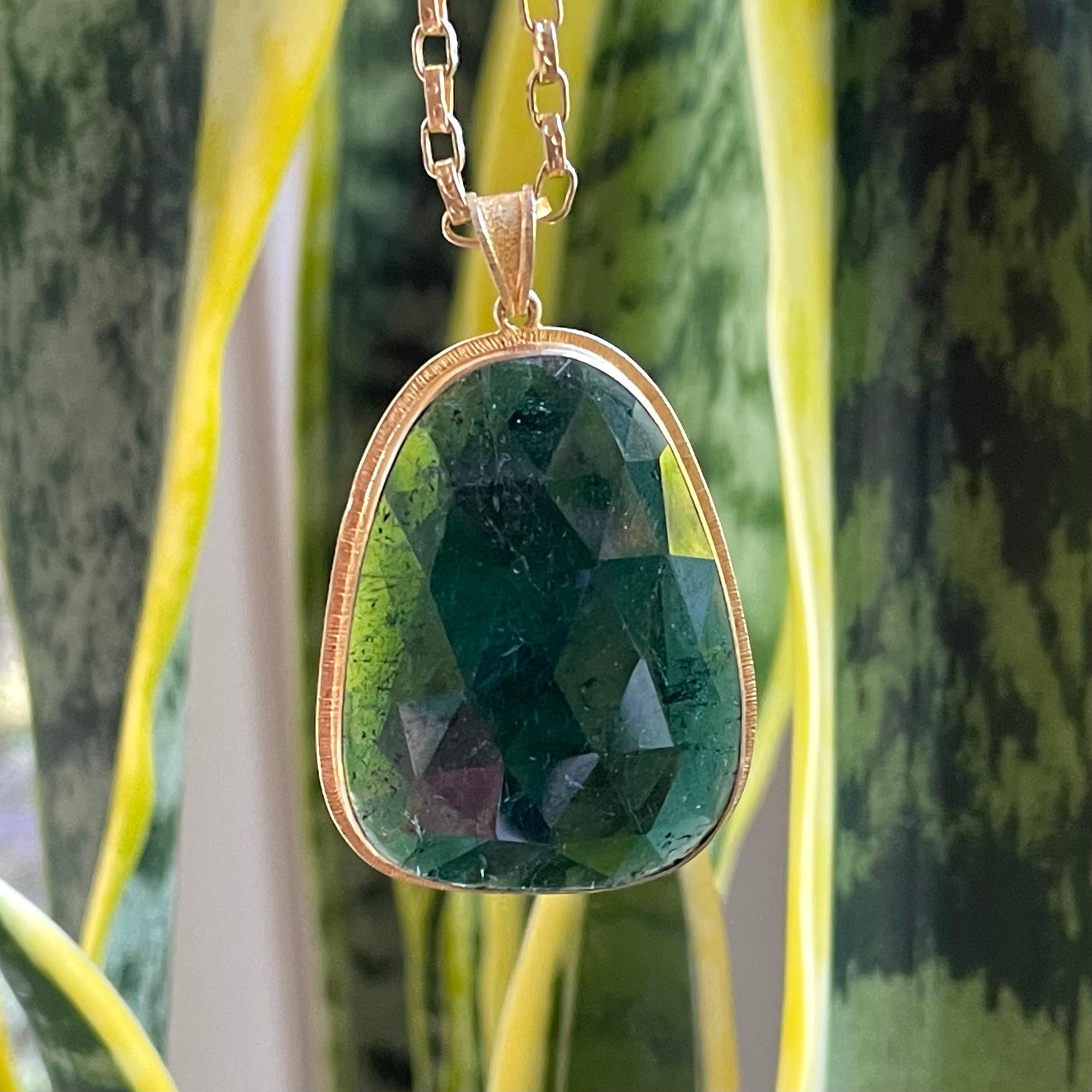 An irregular large rose cut slice of Brazilian green tourmaline is set simply in an organic line texture setting.  A beautiful statement piece !  The chain shown is not included but can be ordered addtionally.

